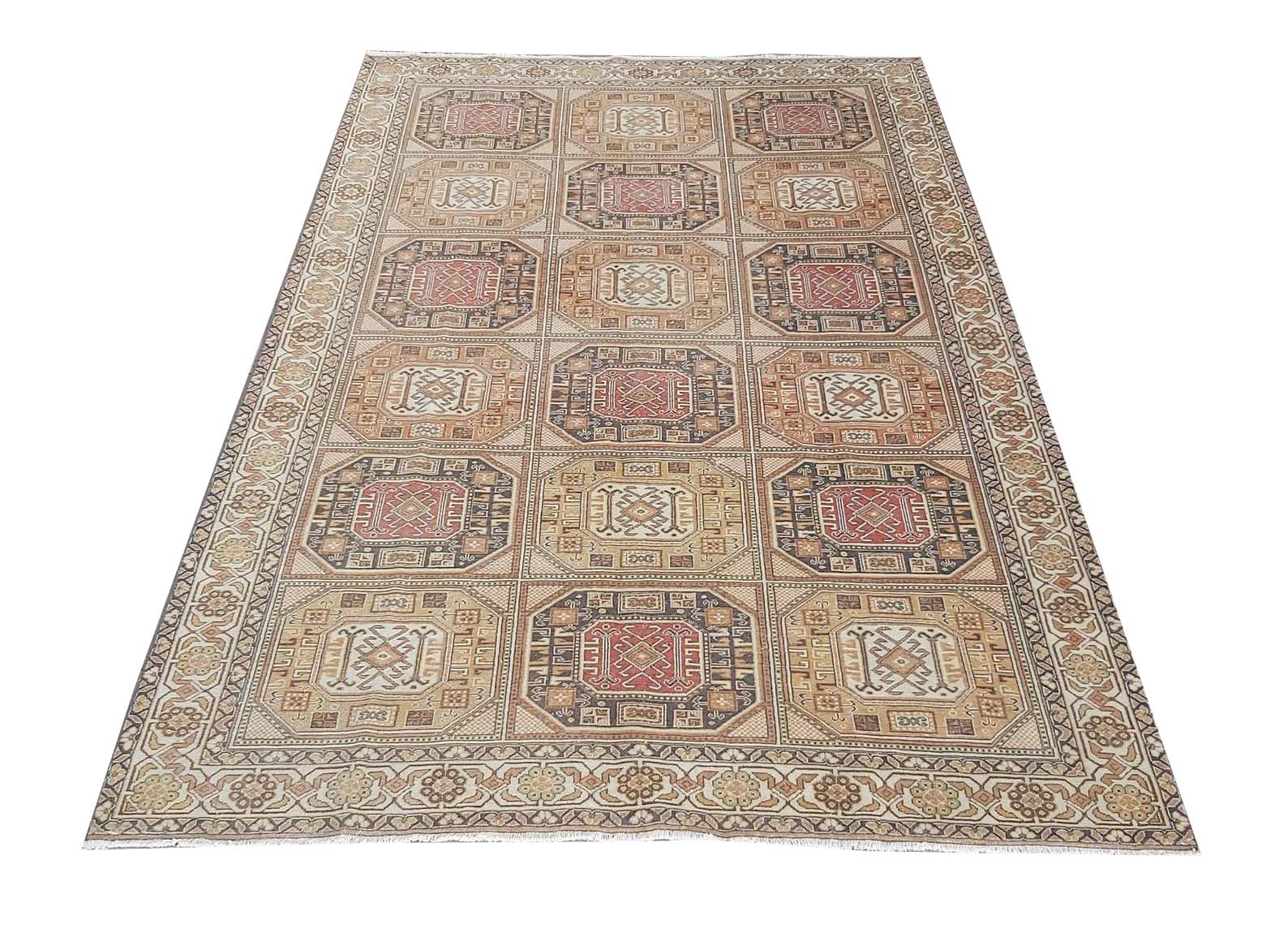 A vintage handmade Turkish Oushak rug featuring a geometric grid pattern in muted earth tones.