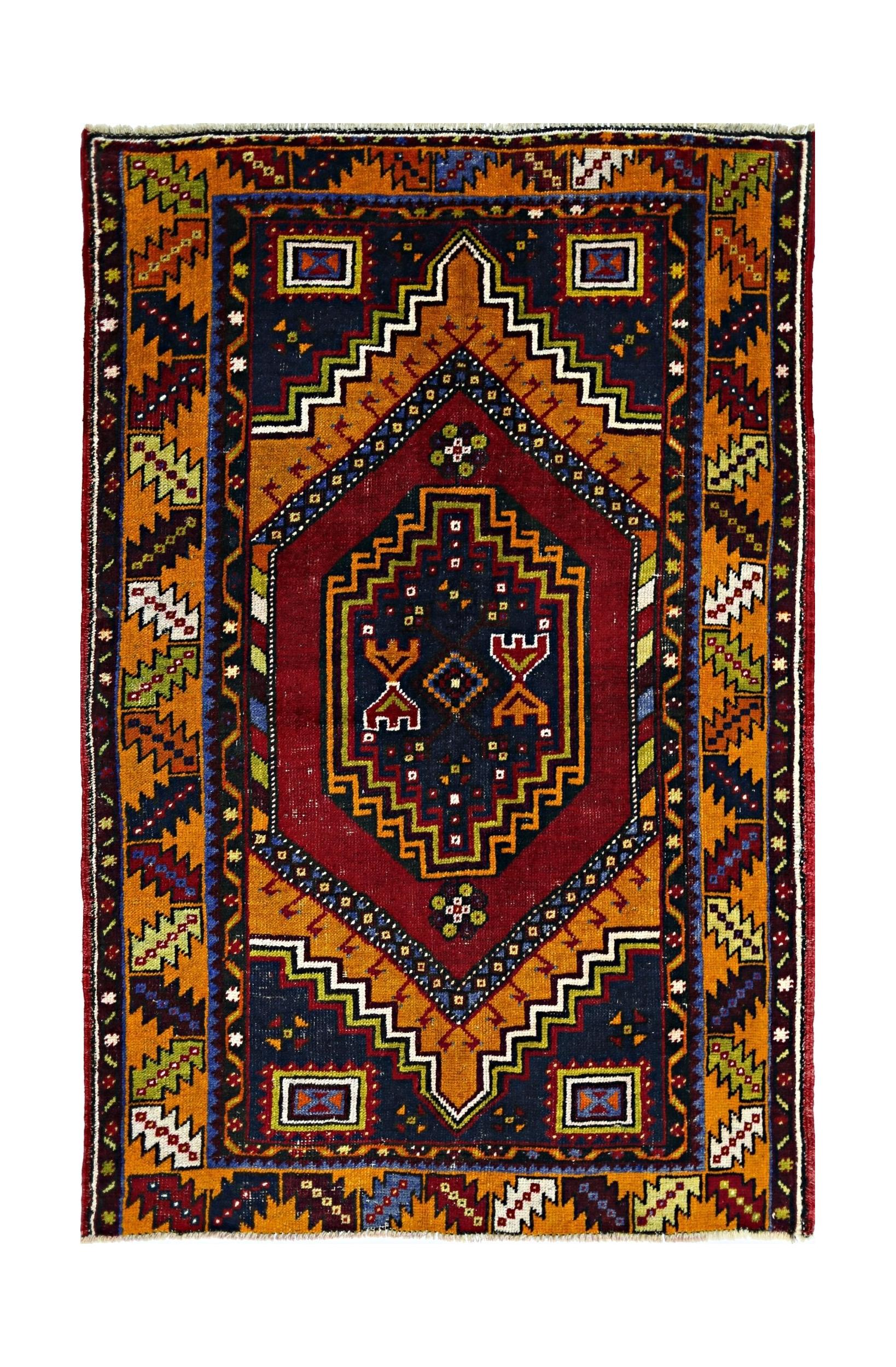 A vintage handmade Turkish Taspinar rug featuring a geometric medallion in red, blue, and orange.