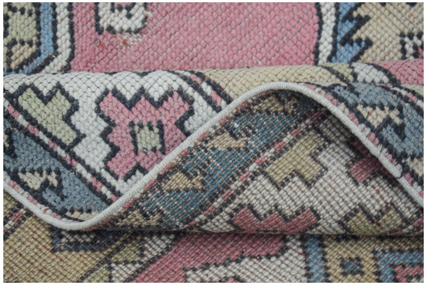 Vintage Turkish Milas rug with pink, blue, and cream geometric patterns.