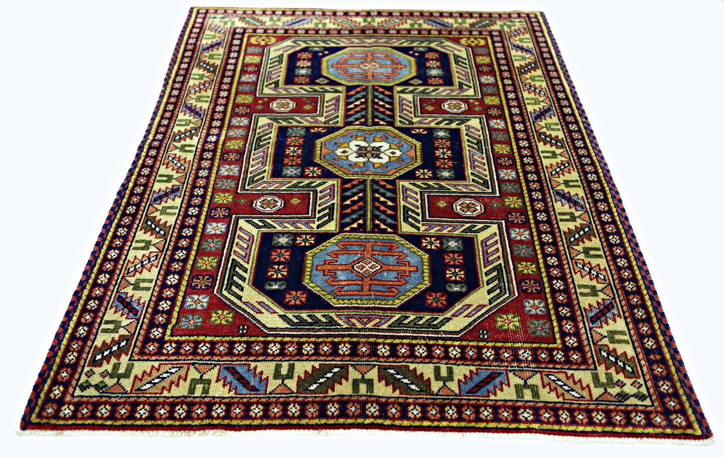 A handmade vintage Turkish wool rug featuring a geometric pattern in blue, red, and cream tones.