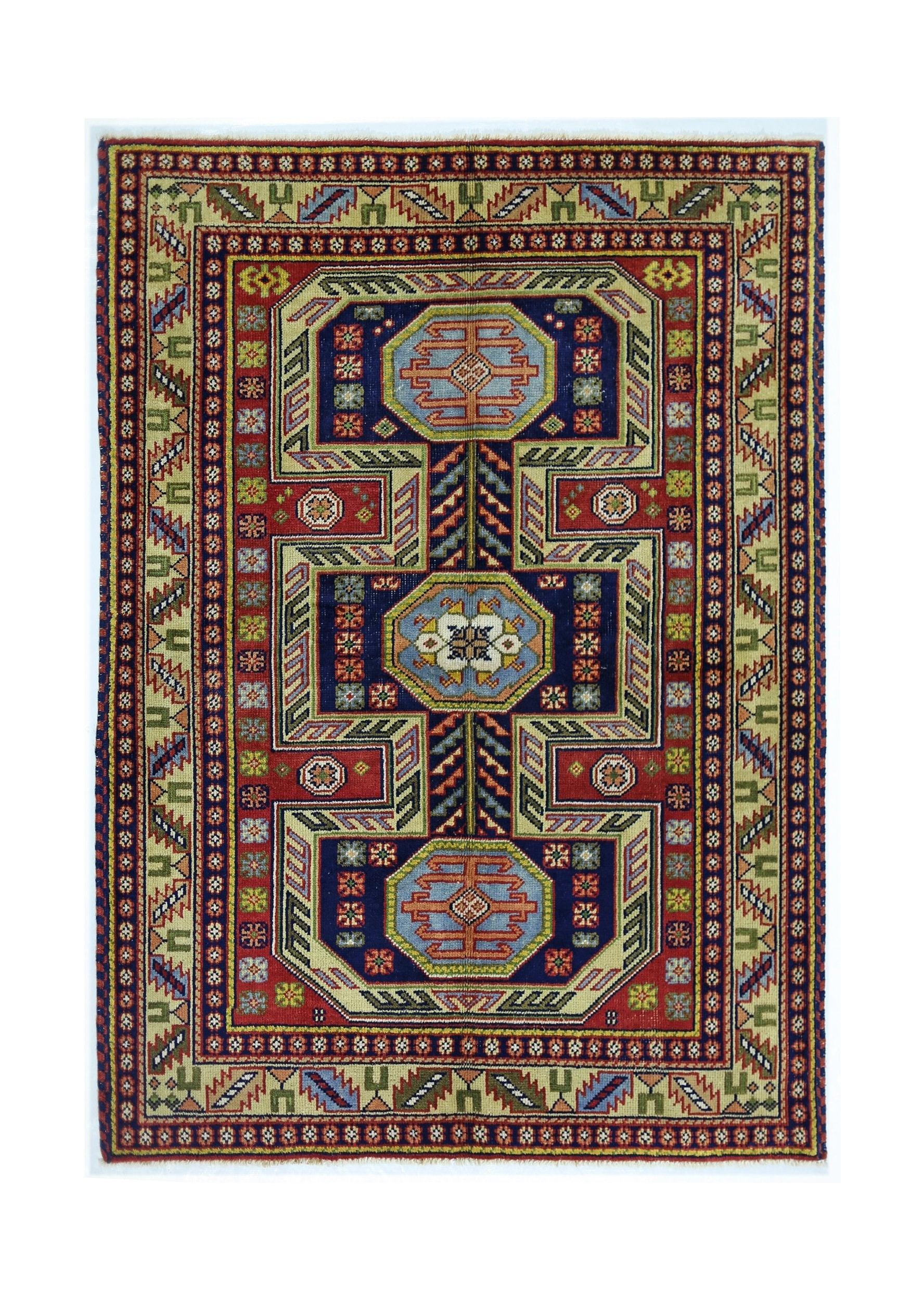 A vintage handmade Turkish rug featuring geometric medallions in blue, red, and beige tones.