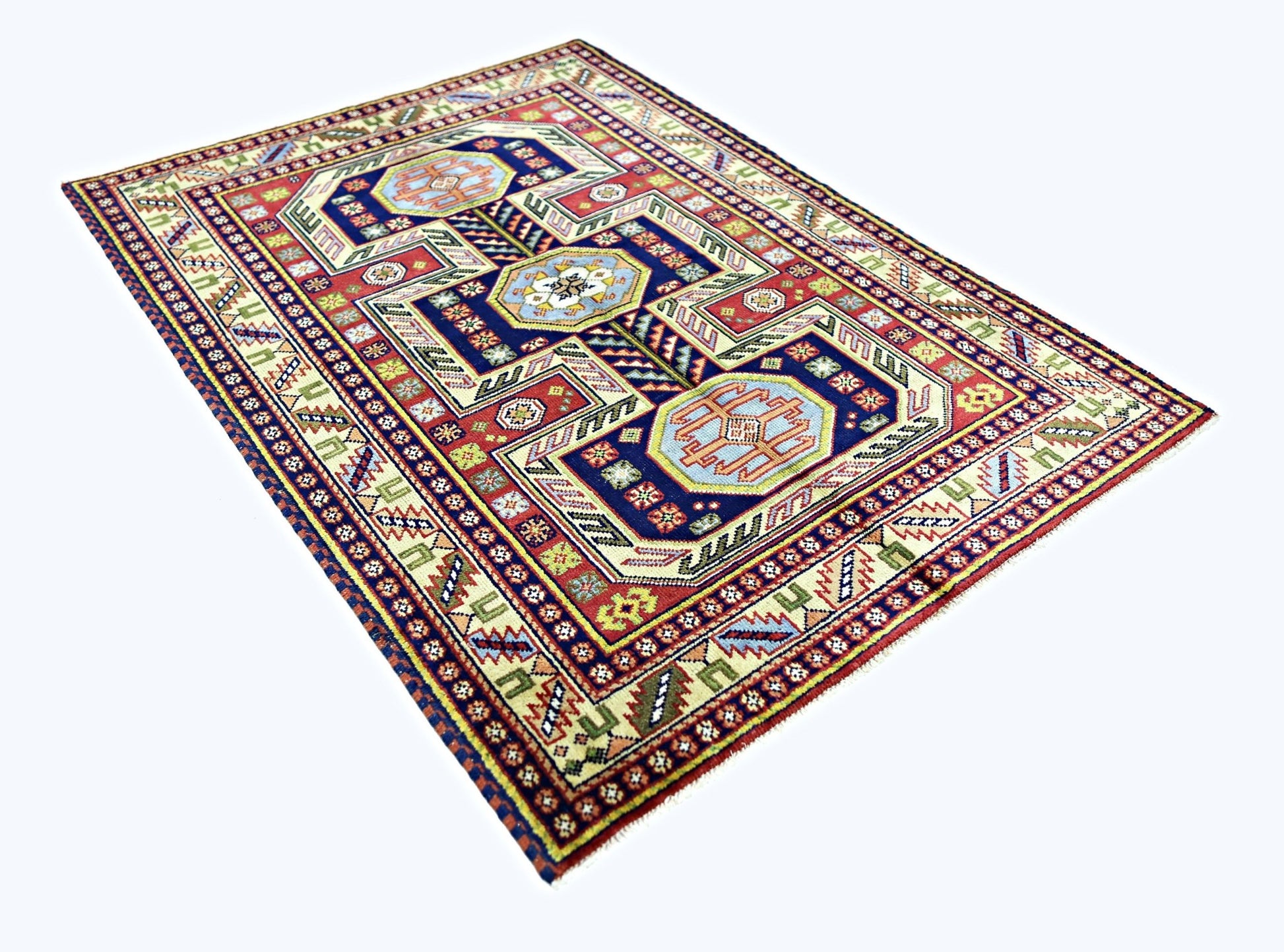 A rectangular vintage Turkish rug featuring geometric patterns in red, blue, and cream tones.