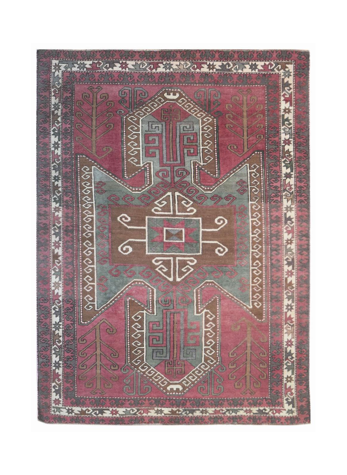A vintage handwoven Iranian rug featuring a geometric medallion in shades of pink, grey, and brown.