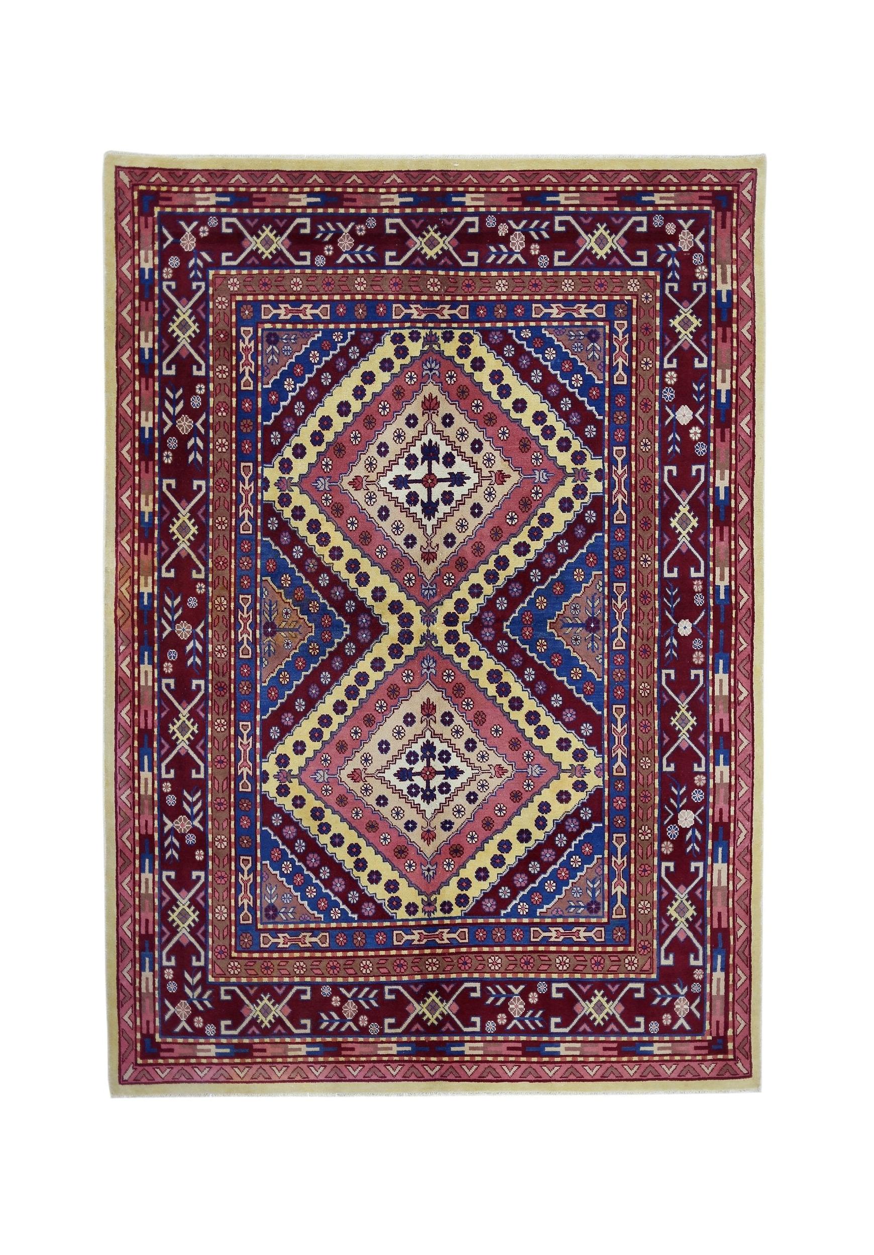 A vintage handmade Turkish rug featuring a geometric diamond pattern in red, blue, and yellow.