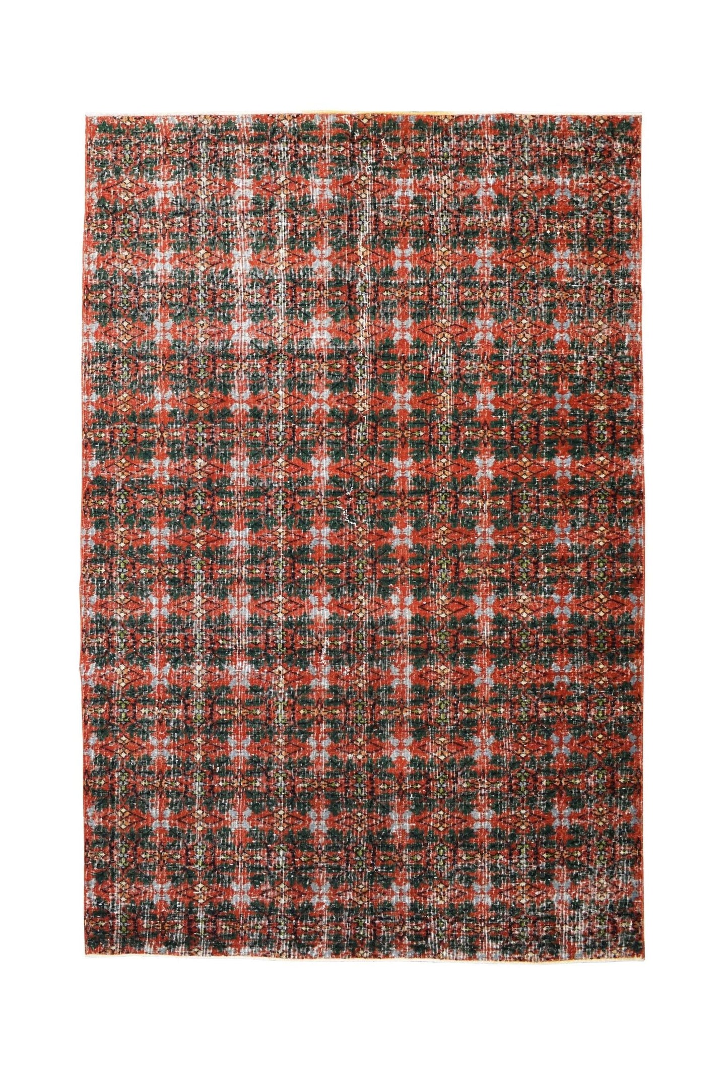 A vintage handmade Turkish rug featuring a repeating geometric pattern in red, green, and grey.