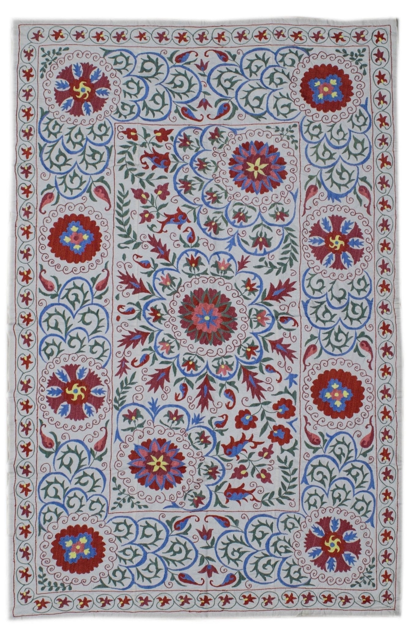 Handmade Uzbek suzani textile featuring intricate floral embroidery on a white cotton base.
