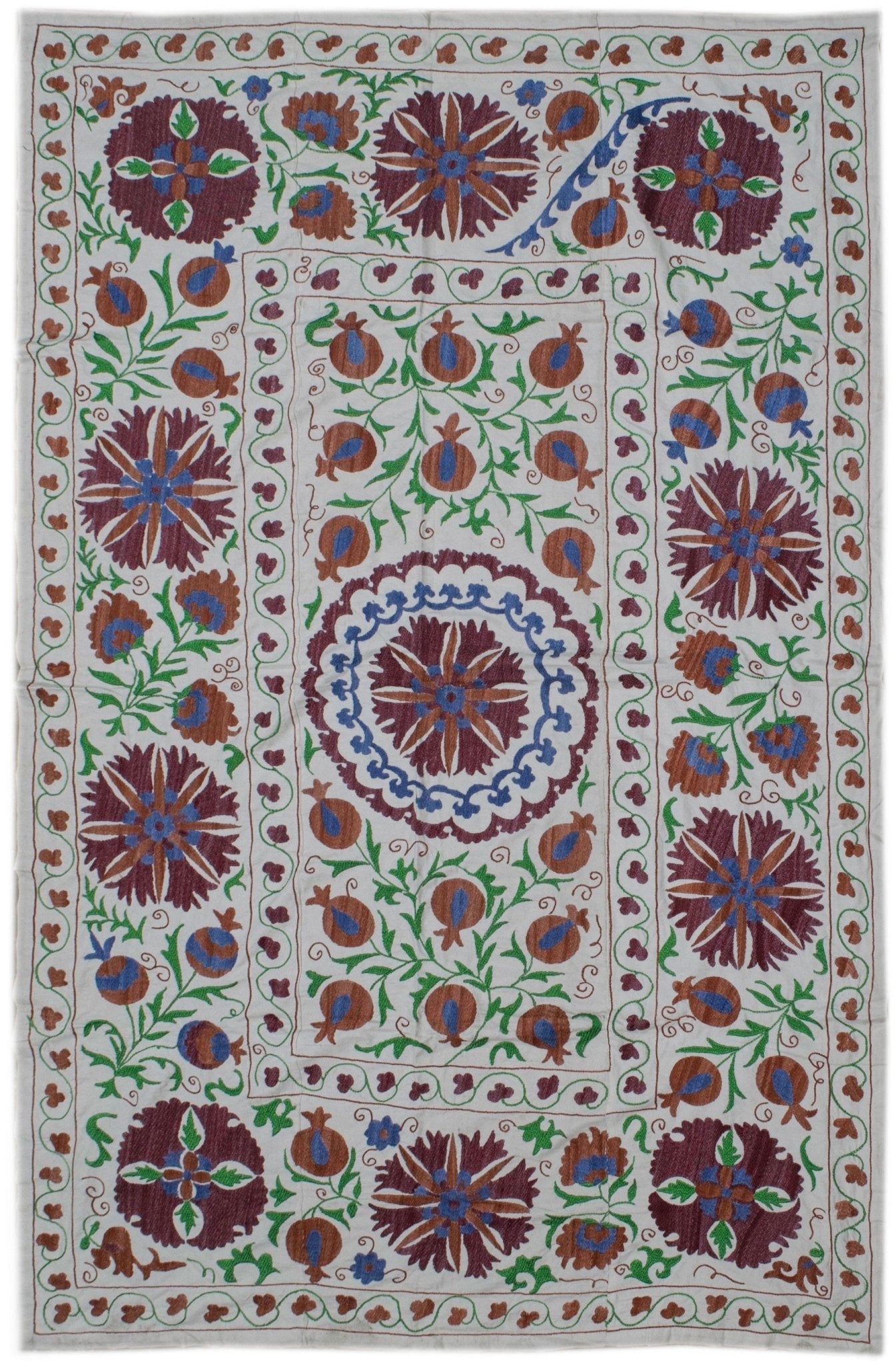 Handmade Uzbek suzani featuring intricate floral and pomegranate embroidery on a cotton base.