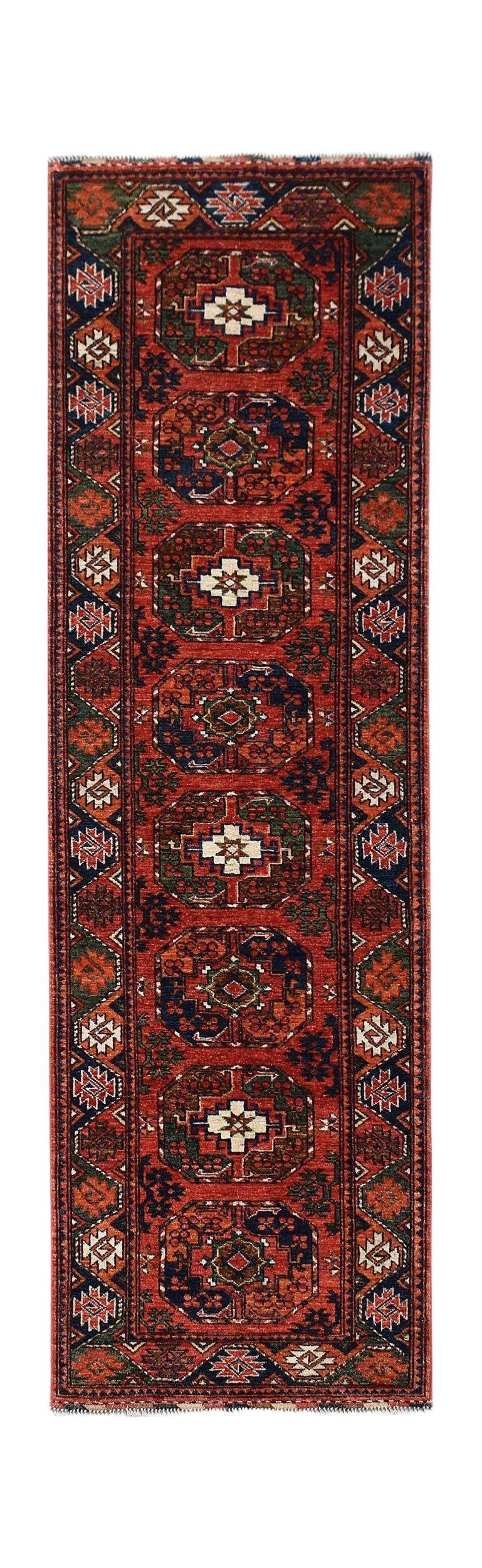 A handmade Afghan Chobi runner rug featuring repeating geometric medallions in red and blue tones.