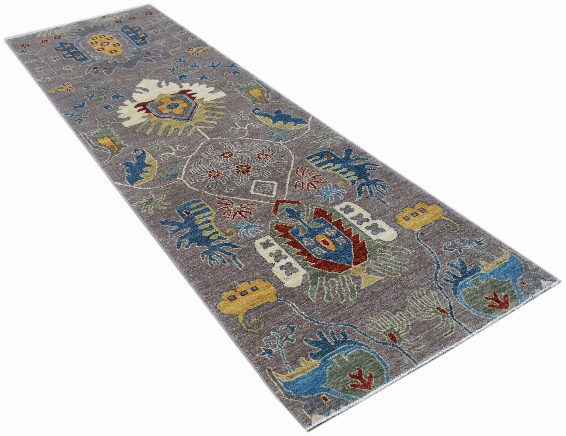 A handwoven Afghan Chobi runner rug featuring traditional floral motifs in a muted grey palette.