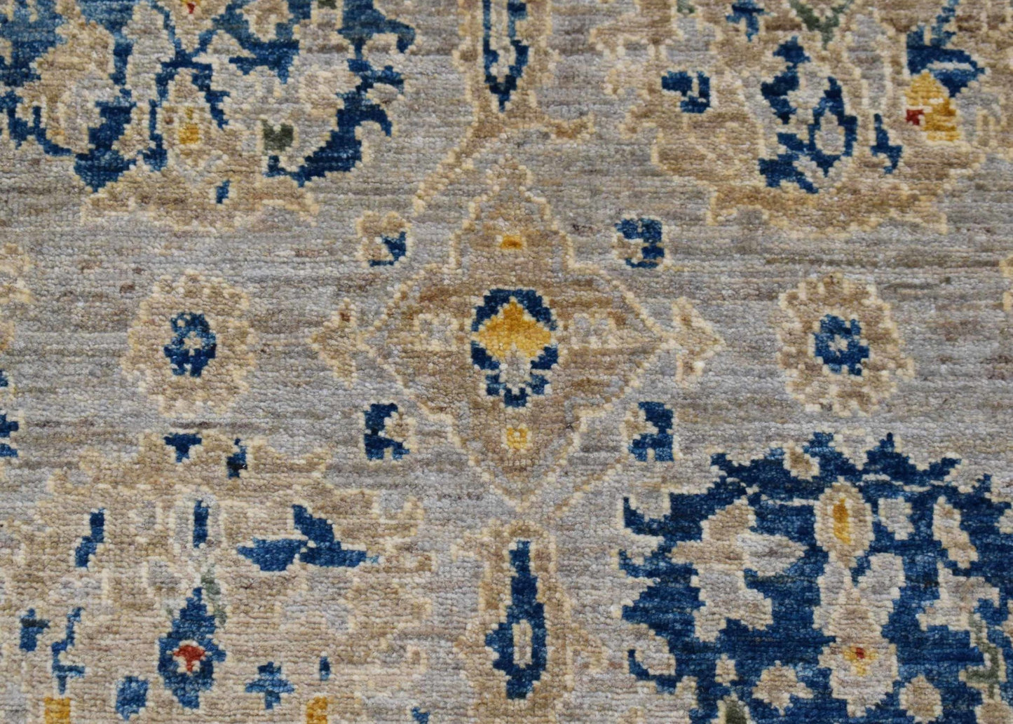 A handwoven Afghan Chobi runner featuring a traditional floral pattern in blue, beige, and gold.