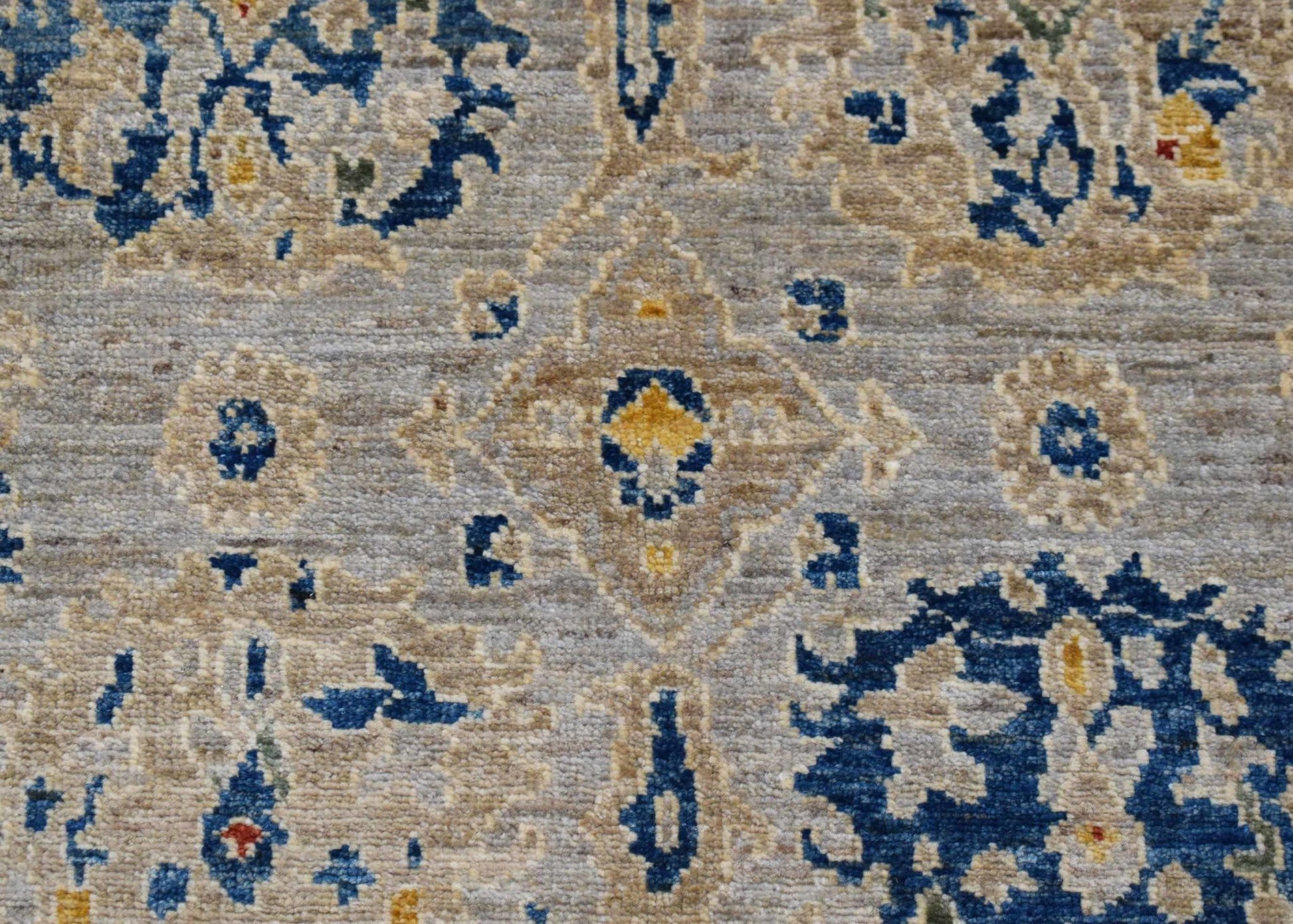 A handwoven Afghan Chobi runner featuring a traditional floral pattern in blue, beige, and gold.
