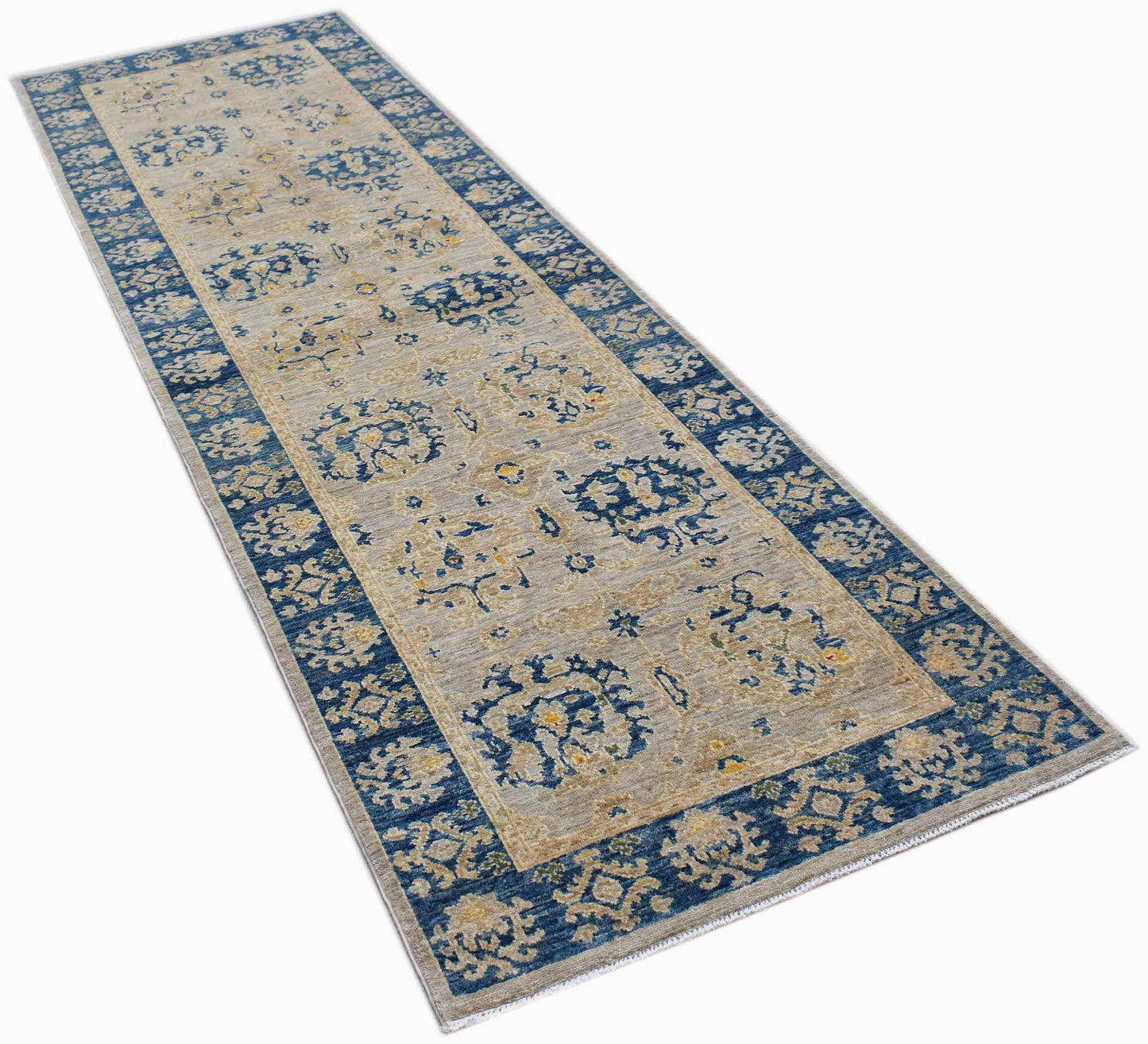 A handmade Afghan Chobi runner rug featuring a blue floral border and a beige patterned center.