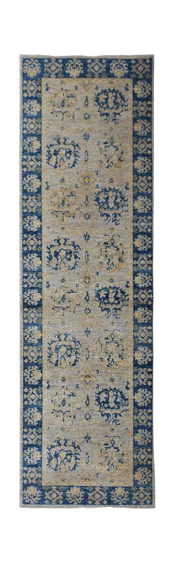 An Afghan Chobi runner rug featuring a blue border and a light grey field with floral motifs.