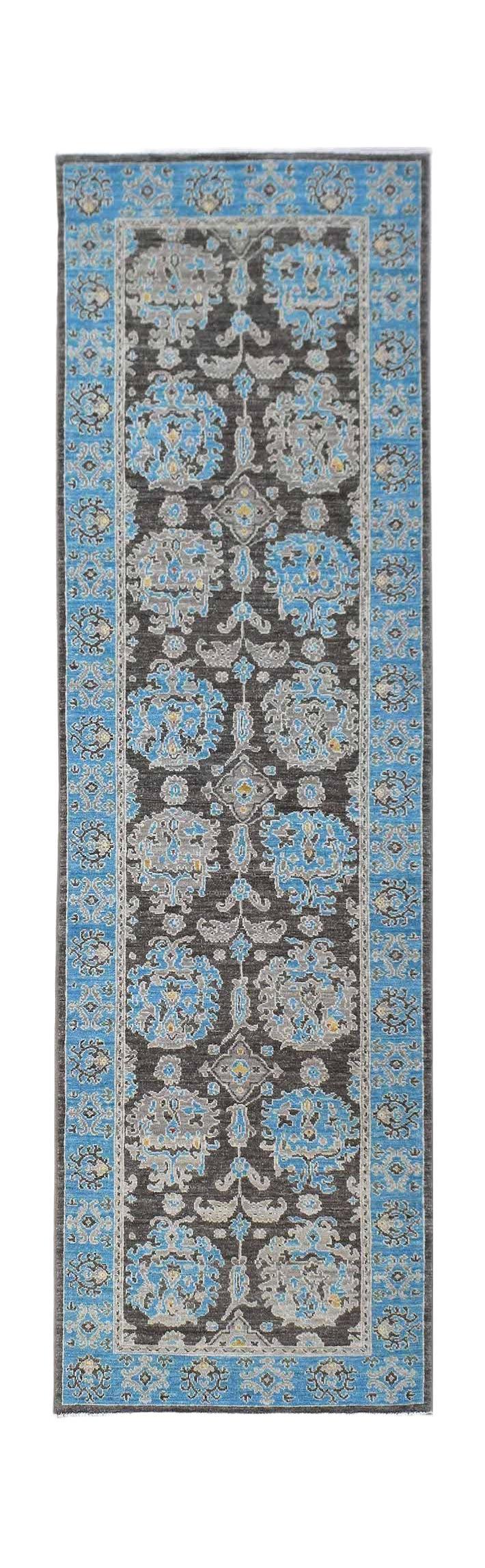 A handmade Afghan Chobi runner rug featuring a dark brown field with blue and grey floral motifs.