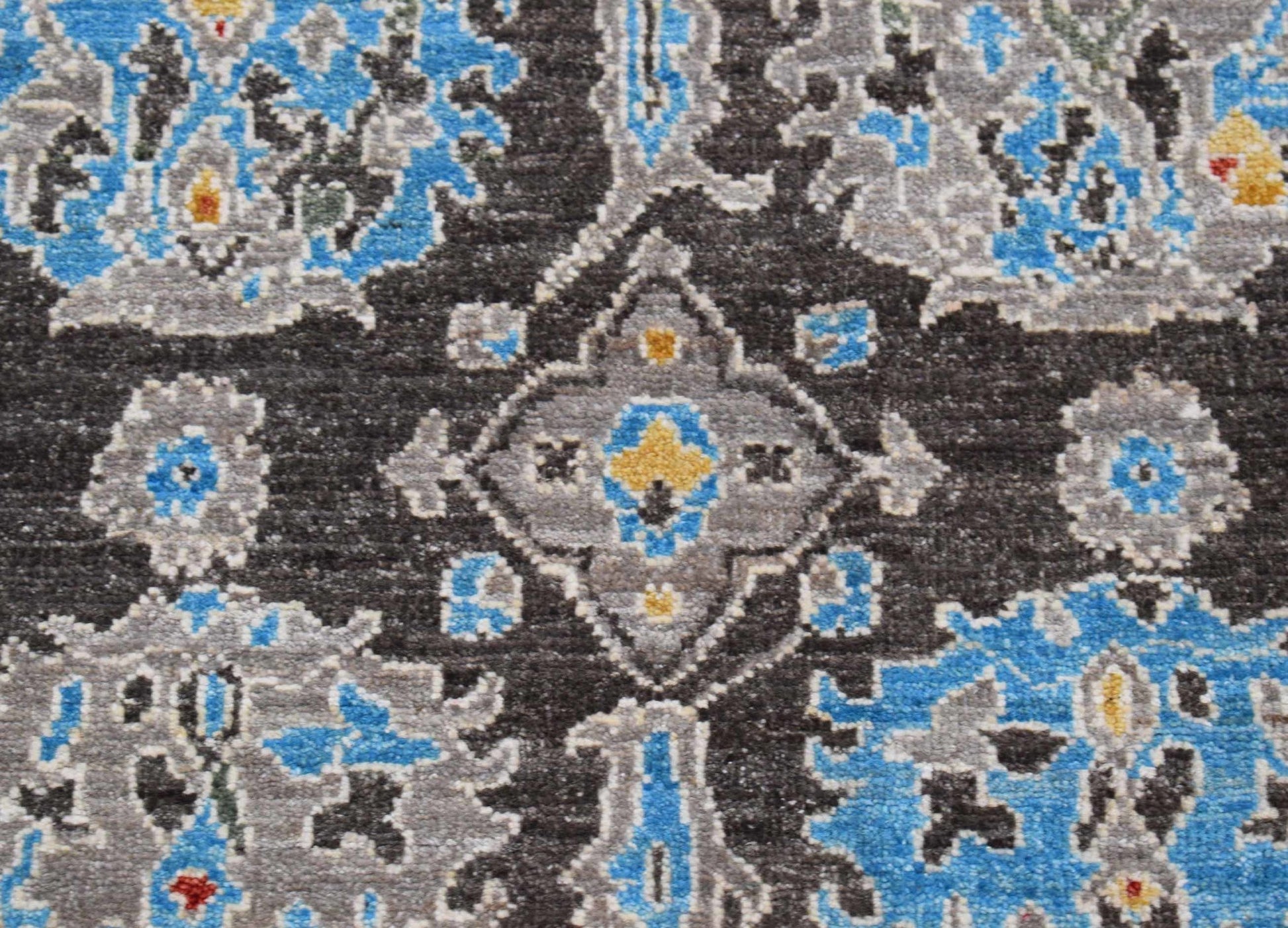 An Afghan Chobi runner featuring a traditional floral pattern in blue, grey, and yellow on black.
