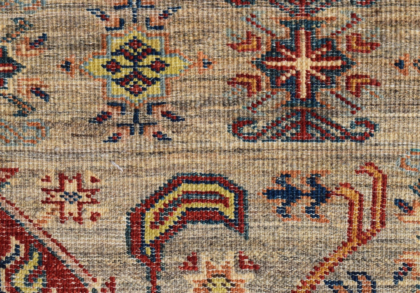 A close-up of an Afghan Chobi runner featuring intricate geometric patterns in earthy tones.