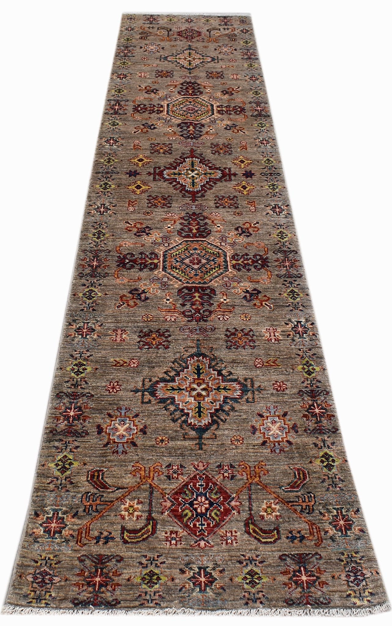 A handwoven Afghan Chobi runner rug featuring traditional geometric patterns in earthy tones.