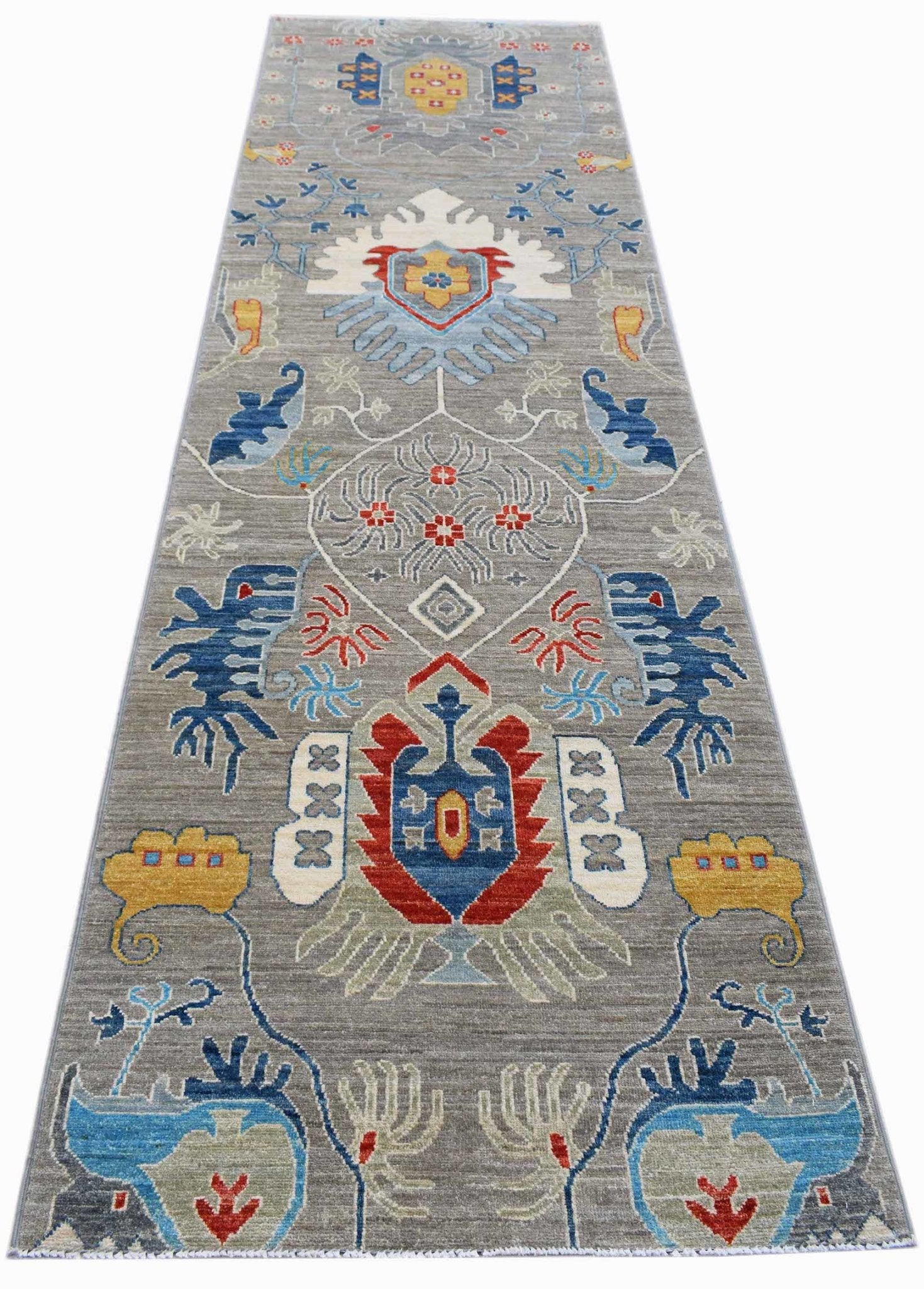 A handmade Afghan Chobi runner rug featuring traditional geometric patterns in blue, red, and gold.