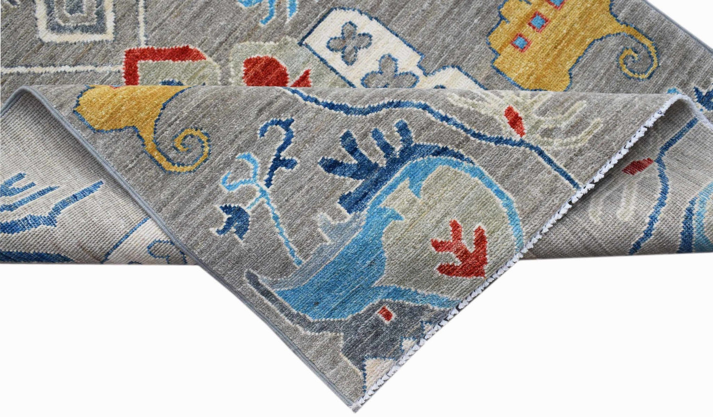 A handwoven Afghan Chobi runner featuring a grey background with colorful traditional motifs.