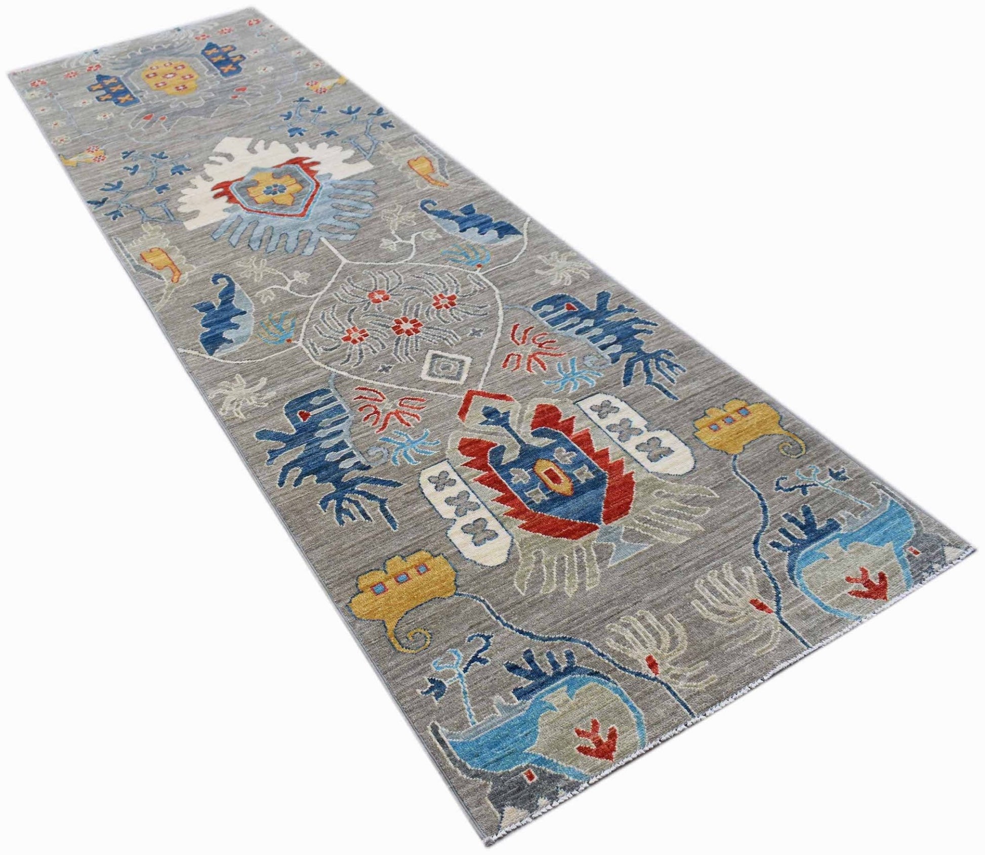 A handmade Afghan Chobi runner rug featuring a grey field with colorful traditional floral motifs.