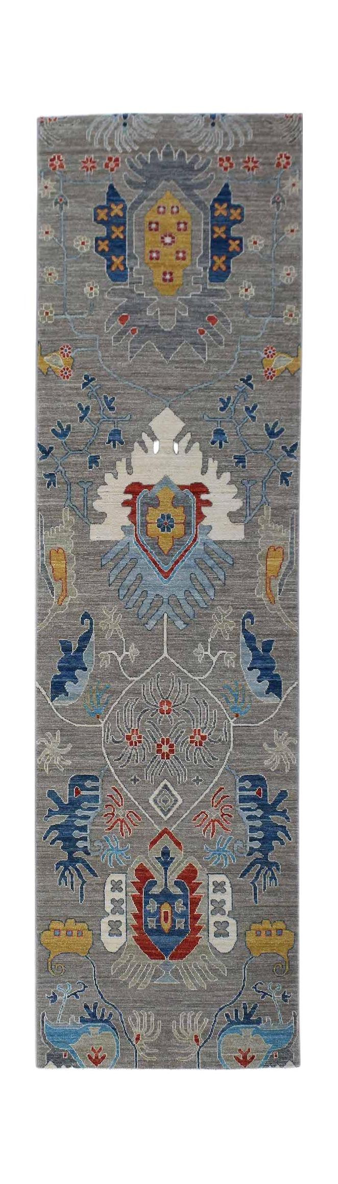 An Afghan Chobi runner rug featuring traditional floral motifs in blue, red, and yellow on grey.