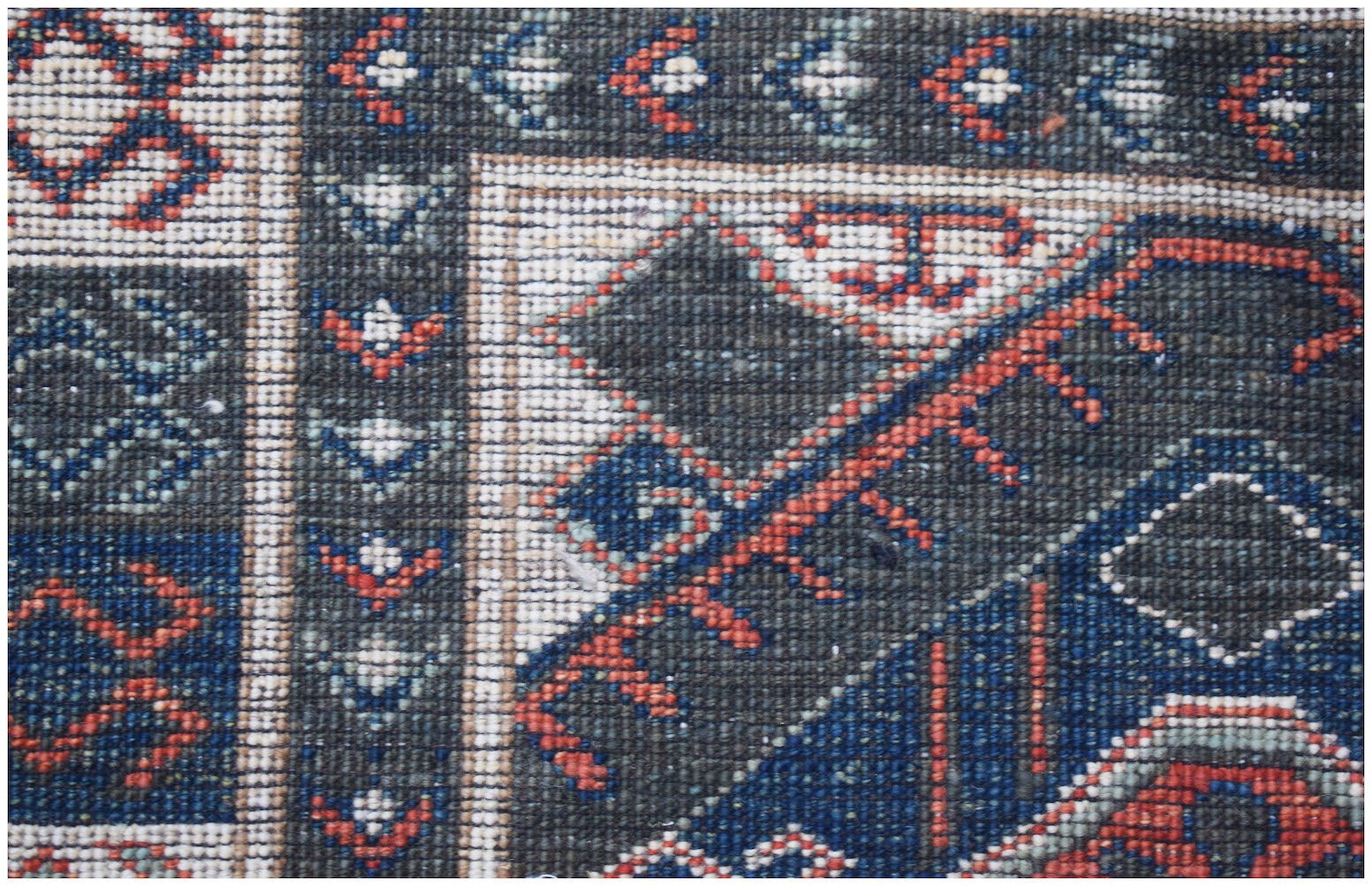 A close-up of a handwoven Afghan Chobi runner featuring intricate geometric patterns in wool.