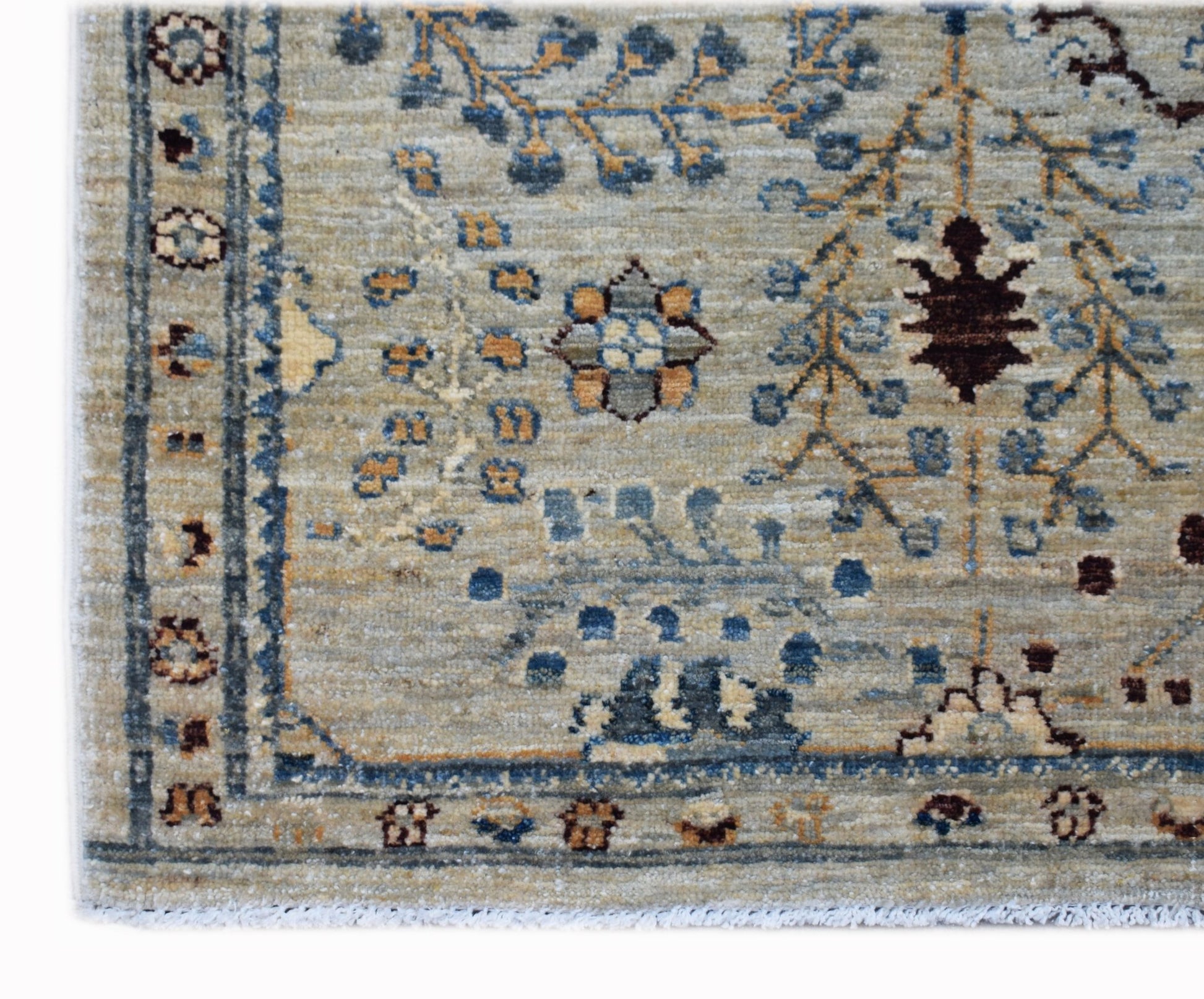 A handwoven Afghan Chobi rug featuring a traditional floral pattern in blue, brown, and beige.