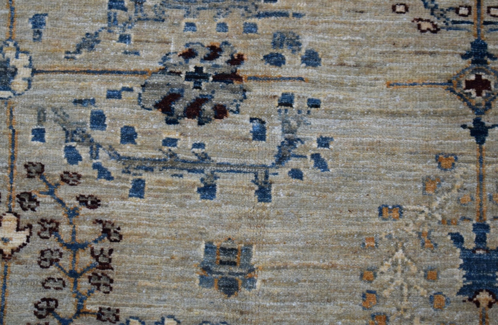 A handwoven Afghan Chobi rug featuring intricate blue and brown floral patterns on a beige field.