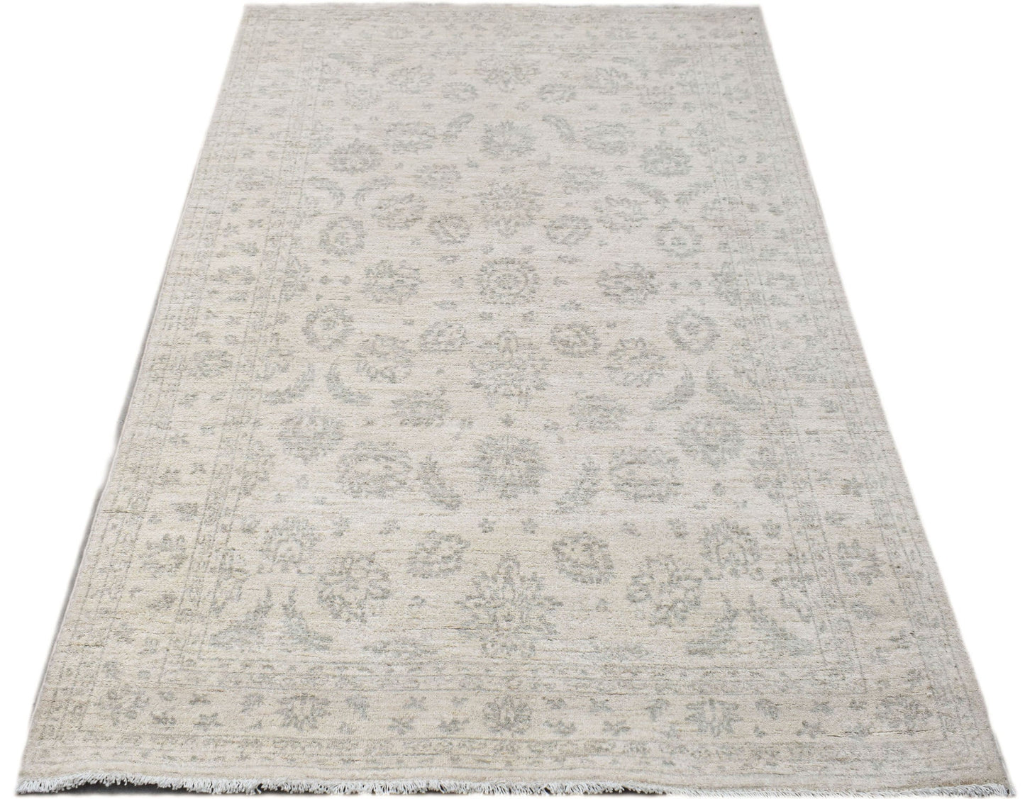 Handwoven Afghan Chobi rug featuring a traditional floral pattern in soft beige and grey tones.