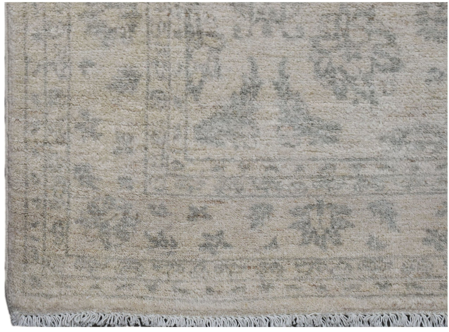 A handmade Afghan Chobi rug featuring a traditional floral pattern in soft beige and grey tones.