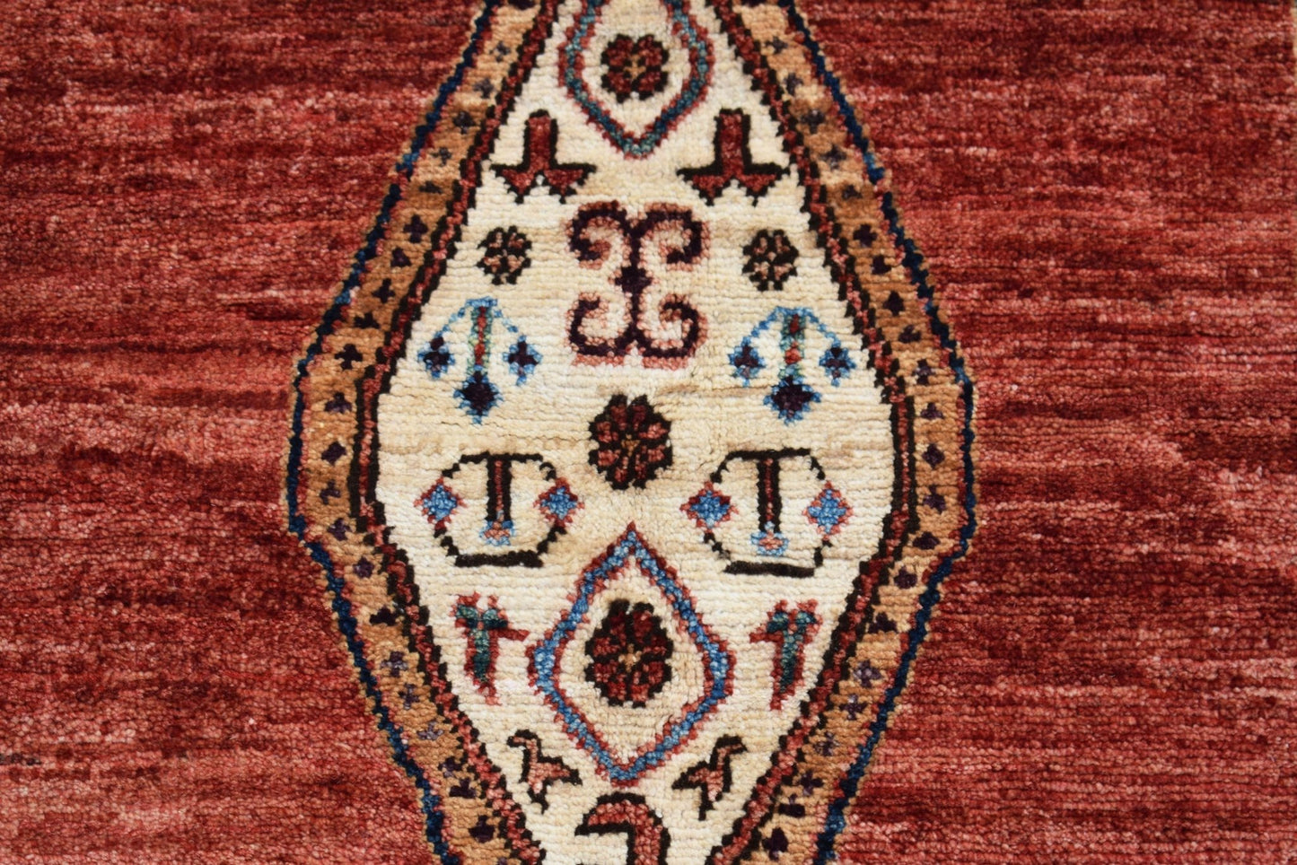 A handmade Afghan Chobi rug featuring a central diamond medallion with intricate geometric motifs.