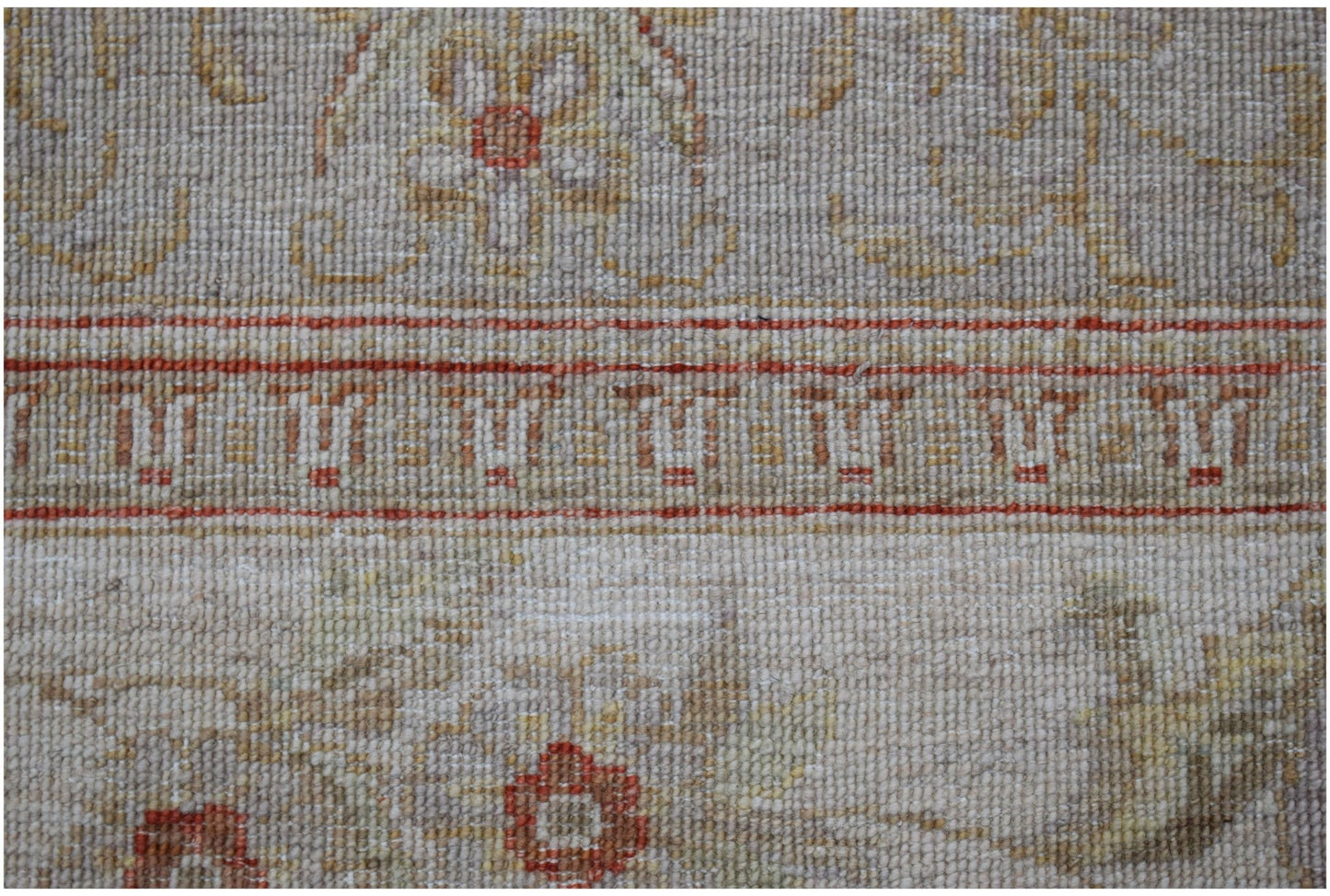 A close-up of a handwoven Afghan Chobi rug featuring traditional floral patterns in earthy tones.