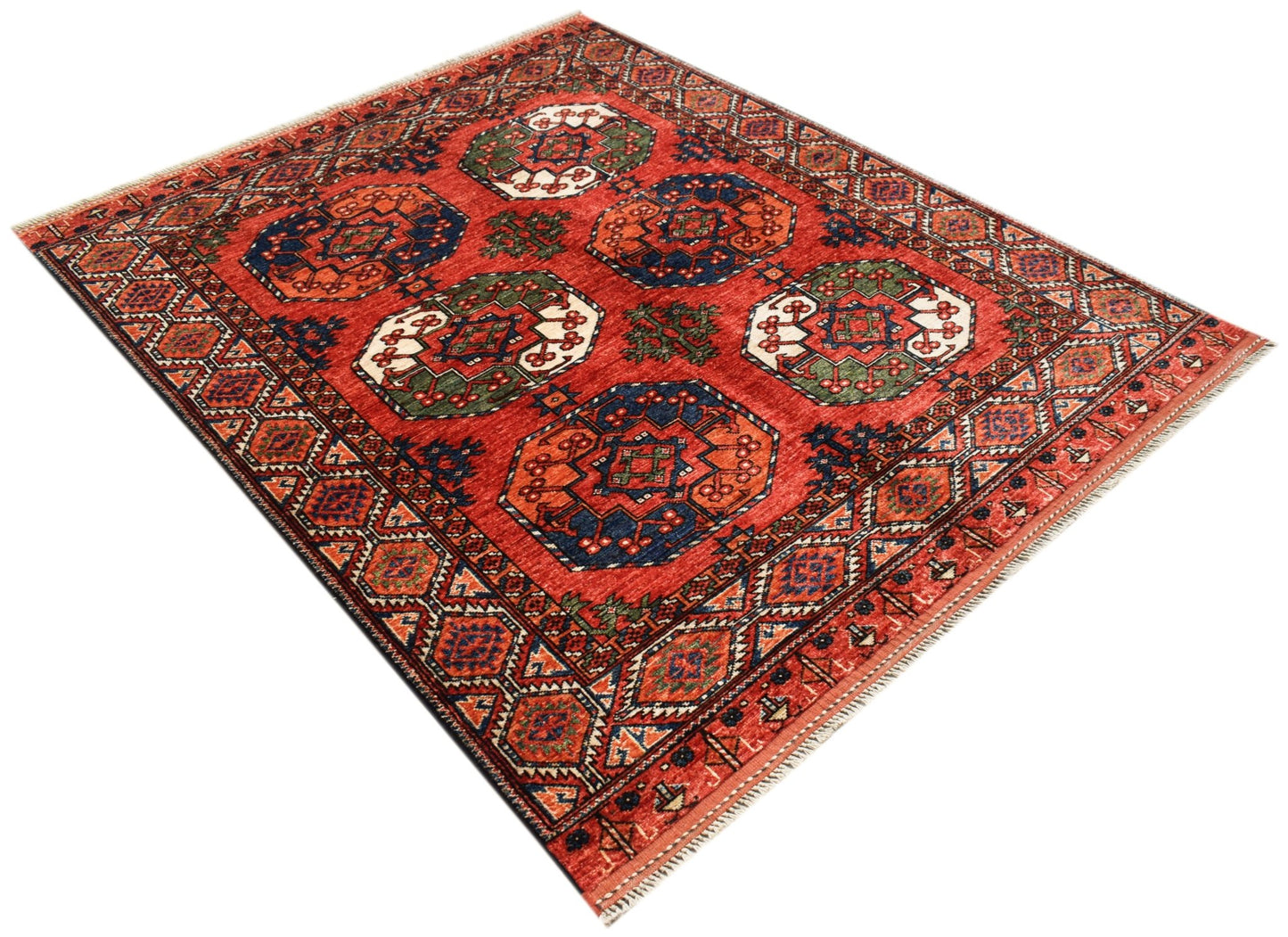 Handwoven Afghan Chobi rug featuring a traditional geometric pattern in red, blue, and green tones.
