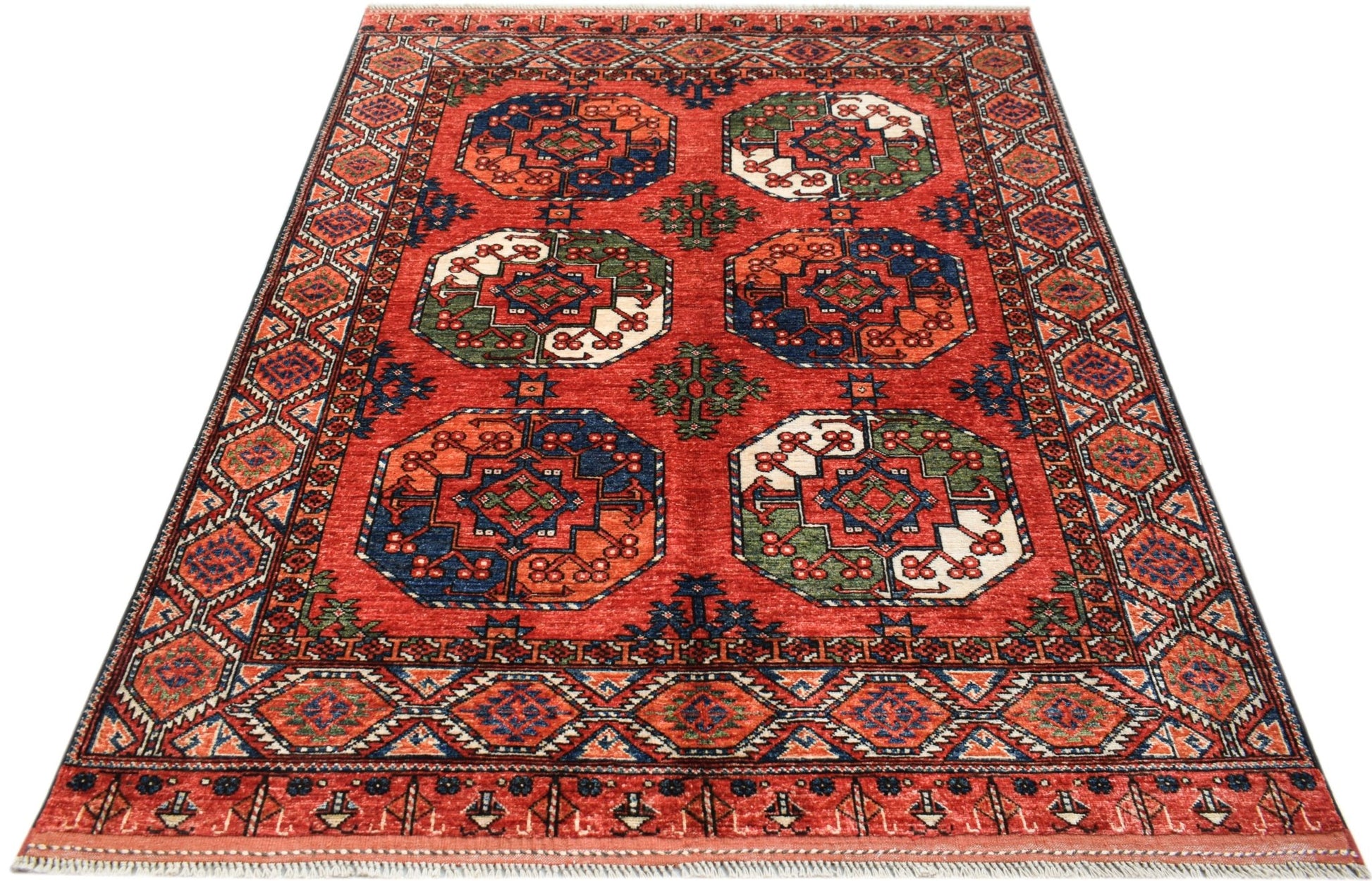 Handwoven Afghan Chobi rug featuring geometric octagonal motifs in red, blue, and green wool.