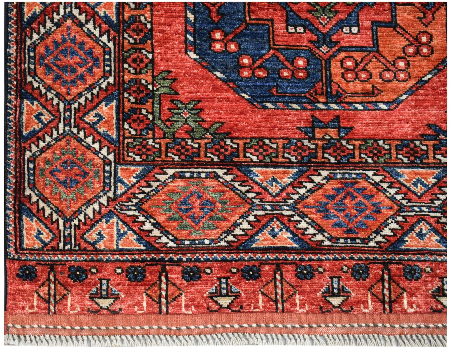 A handmade Afghan Chobi rug featuring traditional geometric patterns in red, blue, and orange.