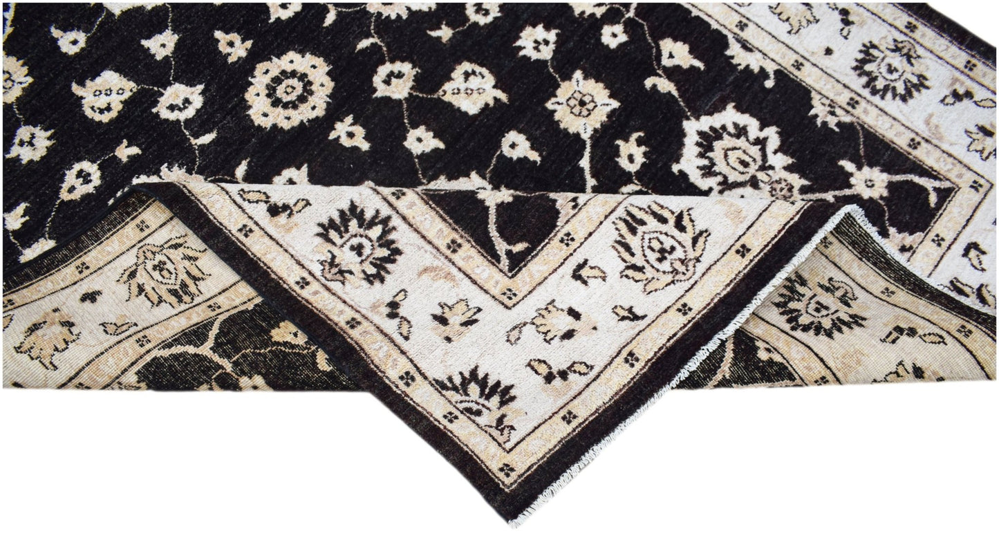 A handwoven Afghan Chobi rug featuring a black field with cream floral patterns and a wide border.
