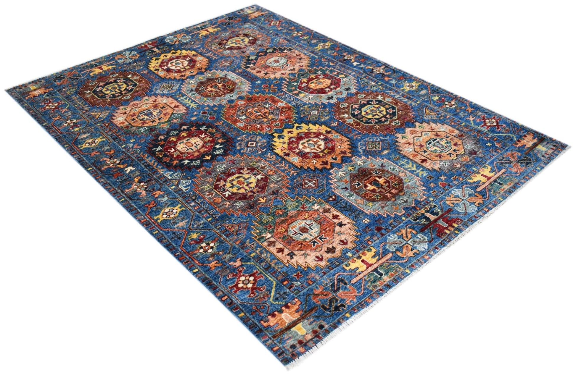 A handmade Afghan Chobi rug featuring a blue field with repeating geometric medallion patterns.