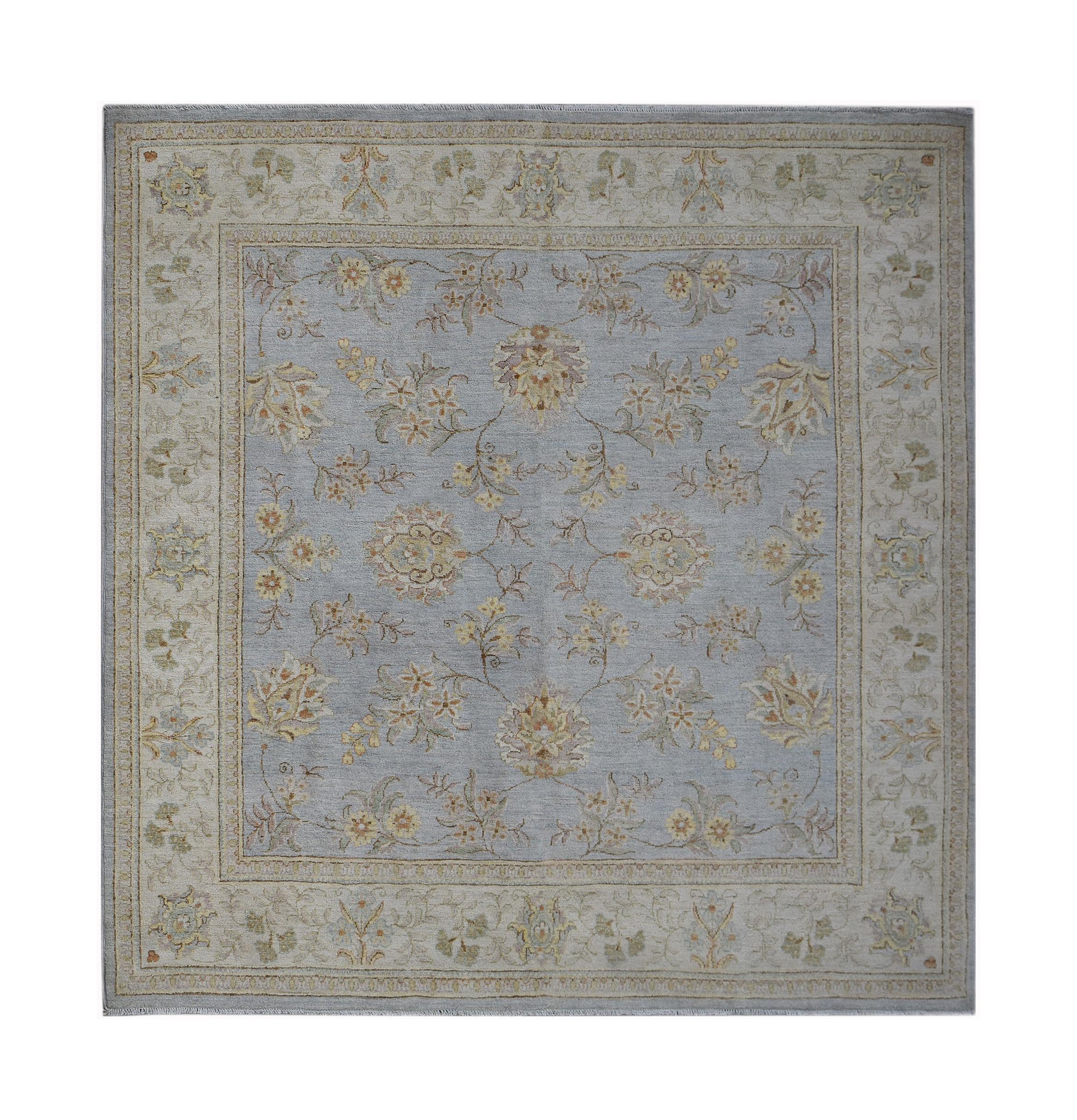 A rectangular Afghan Chobi rug featuring a light blue field with a traditional floral pattern.