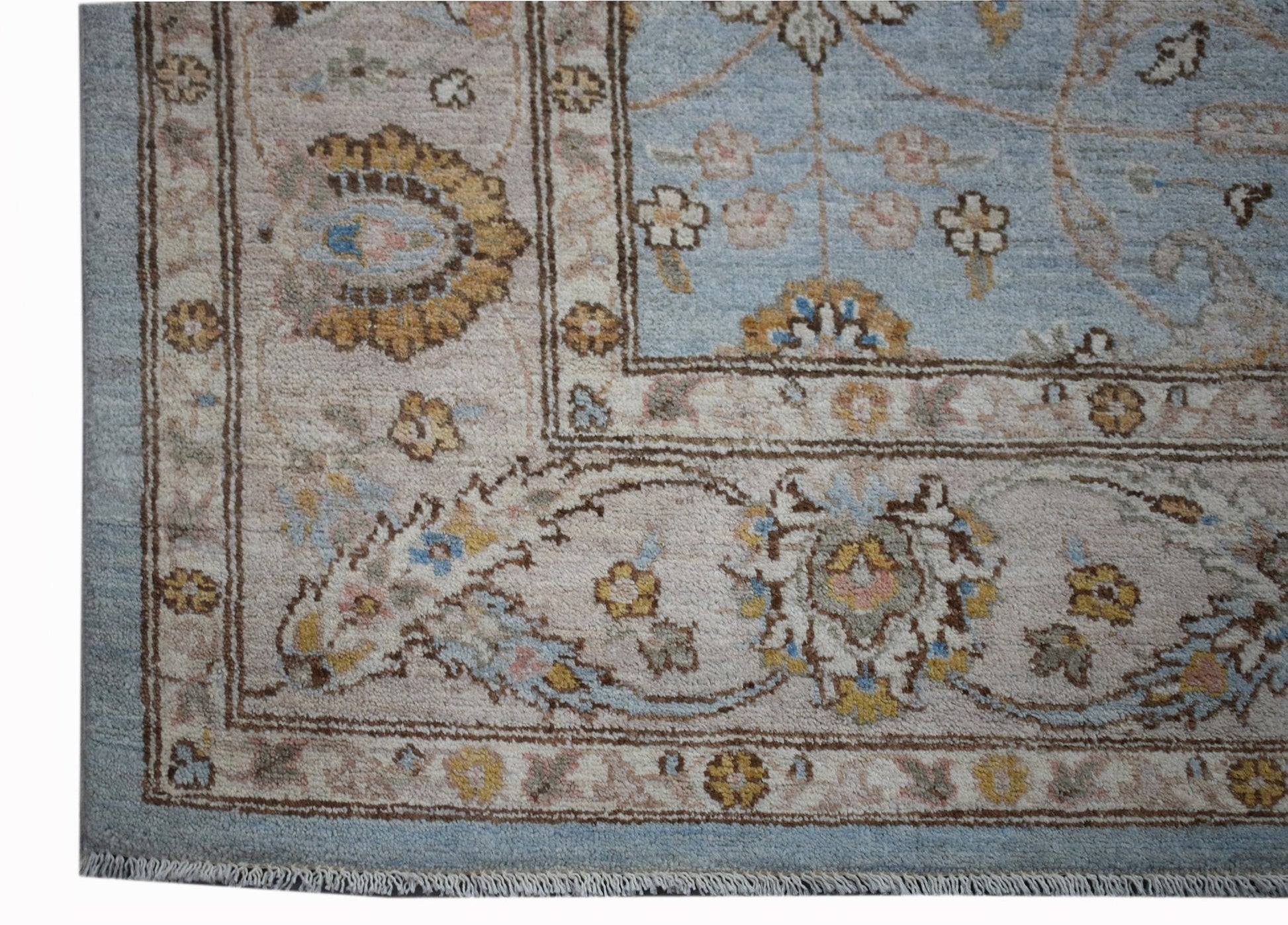 A handmade Afghan Chobi rug featuring a traditional floral pattern in soft blue and beige tones.