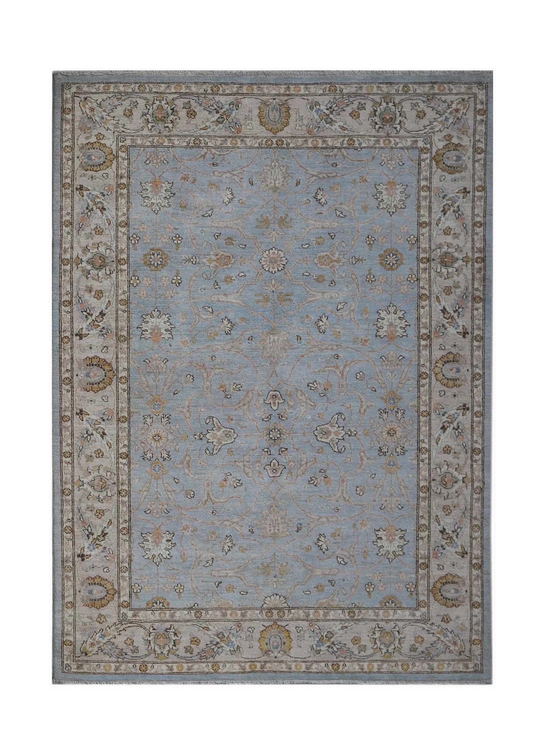 A rectangular Afghan Chobi rug featuring a light blue field with traditional floral patterns.