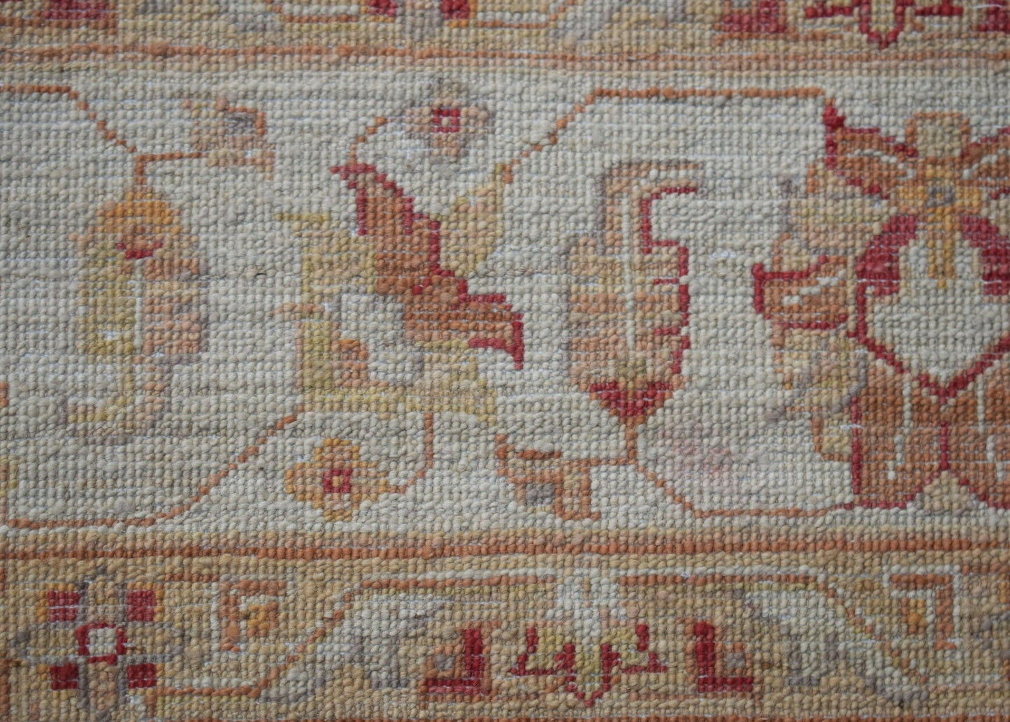A close-up of a handwoven Afghan Chobi rug featuring traditional floral patterns in earthy tones.