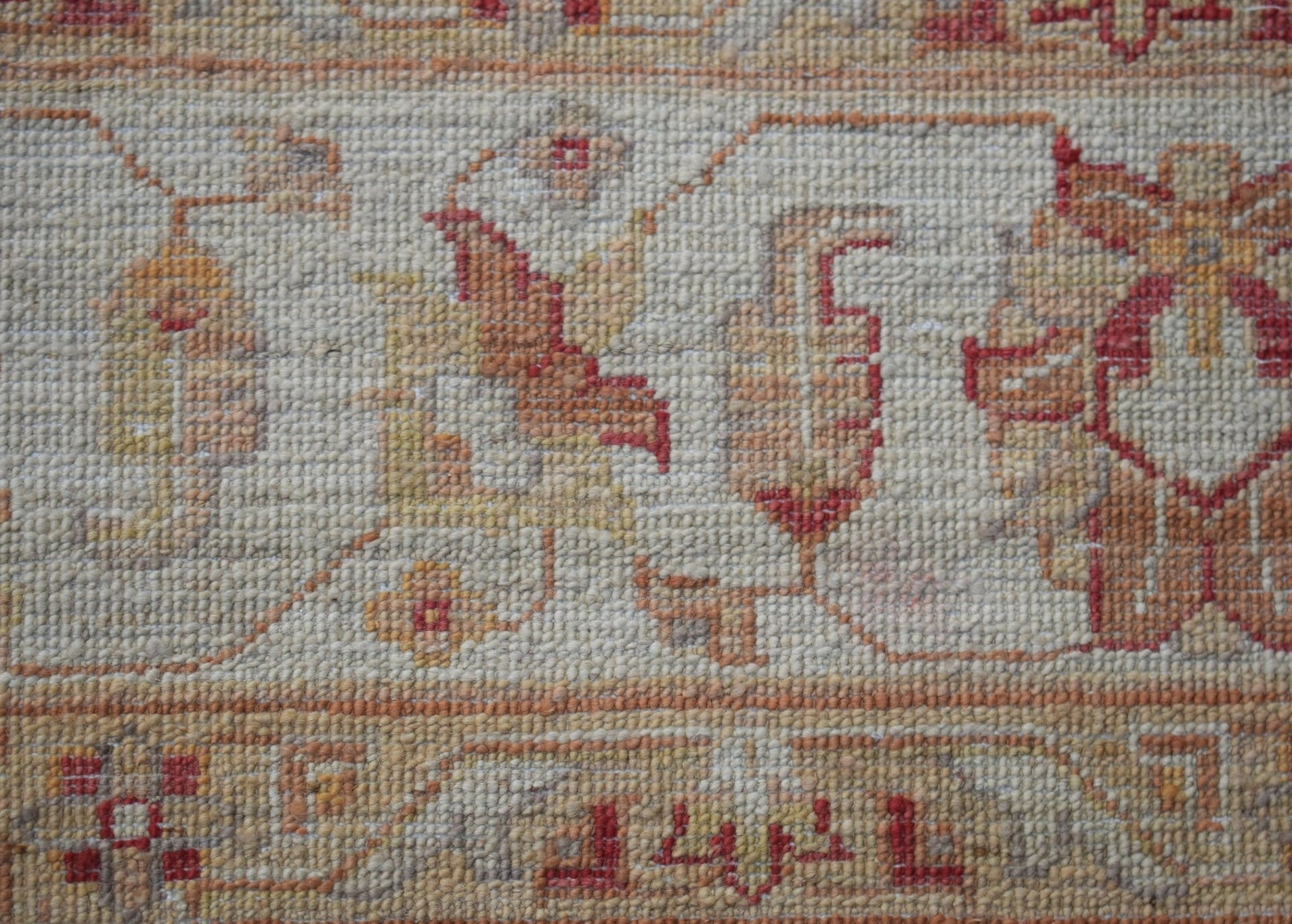 A close-up of a handwoven Afghan Chobi rug featuring traditional floral patterns in earthy tones.
