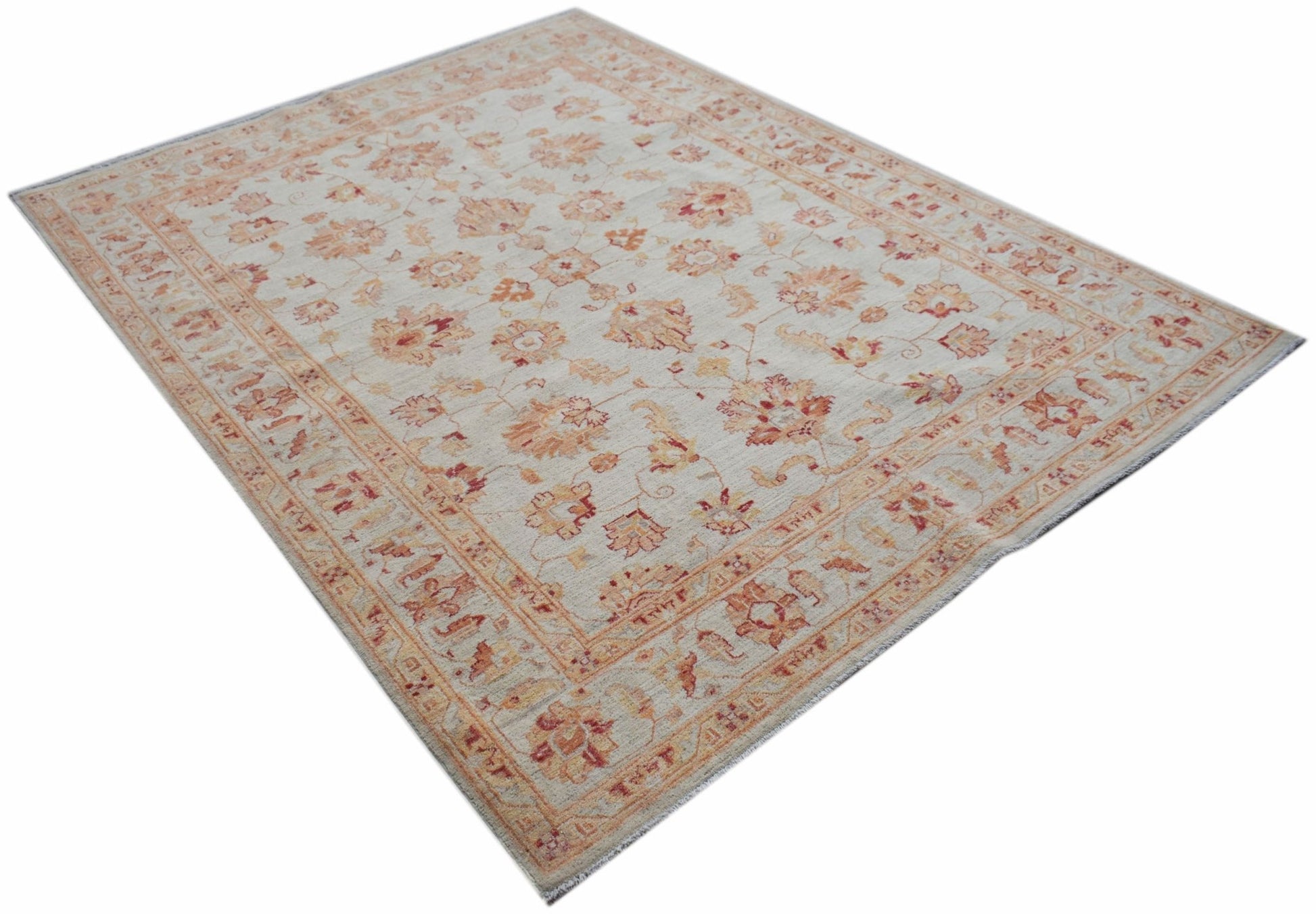 An Afghan Chobi rug featuring a traditional floral pattern in warm wood tones on a cream background.