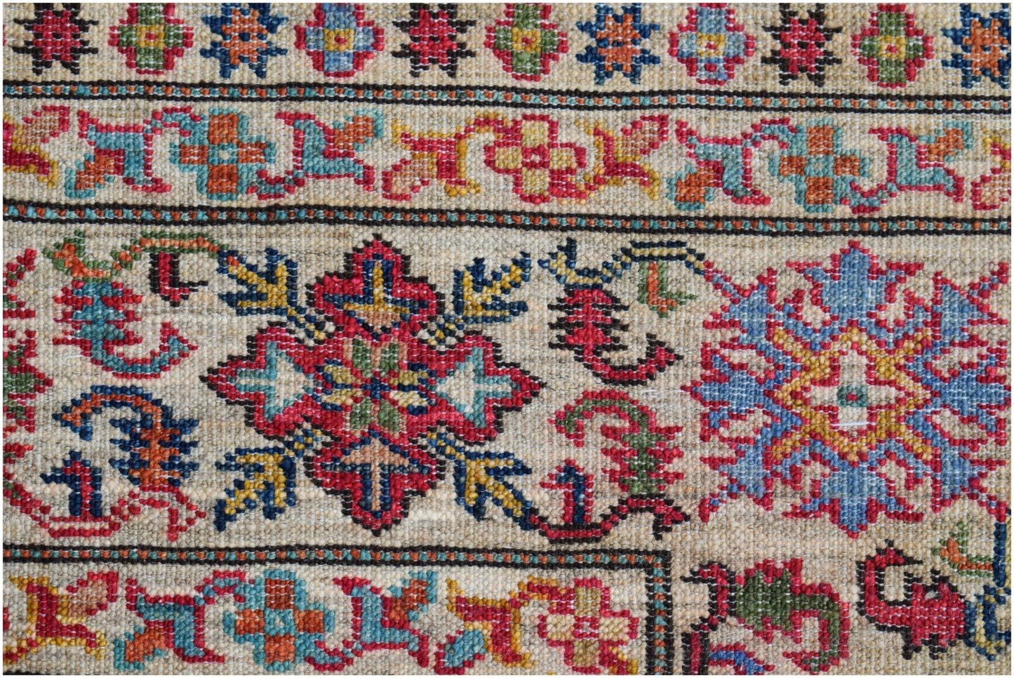 A close-up of an Afghan Super Kazakh rug featuring intricate geometric floral patterns in wool.