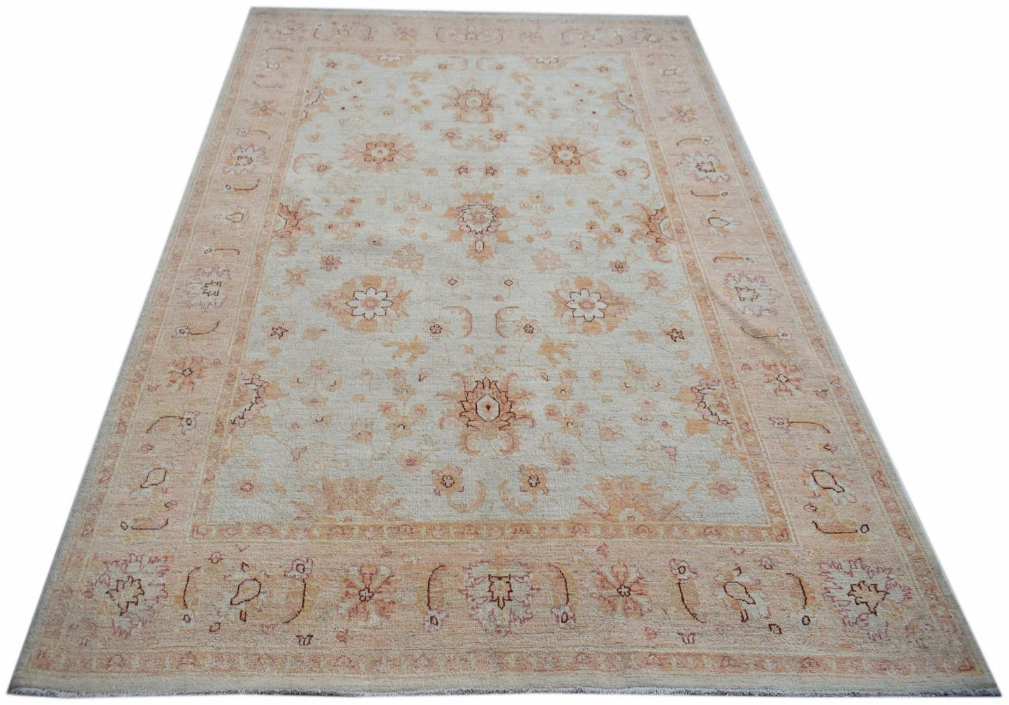 An Afghan Chobi rug featuring a traditional floral pattern in soft beige and peach tones.