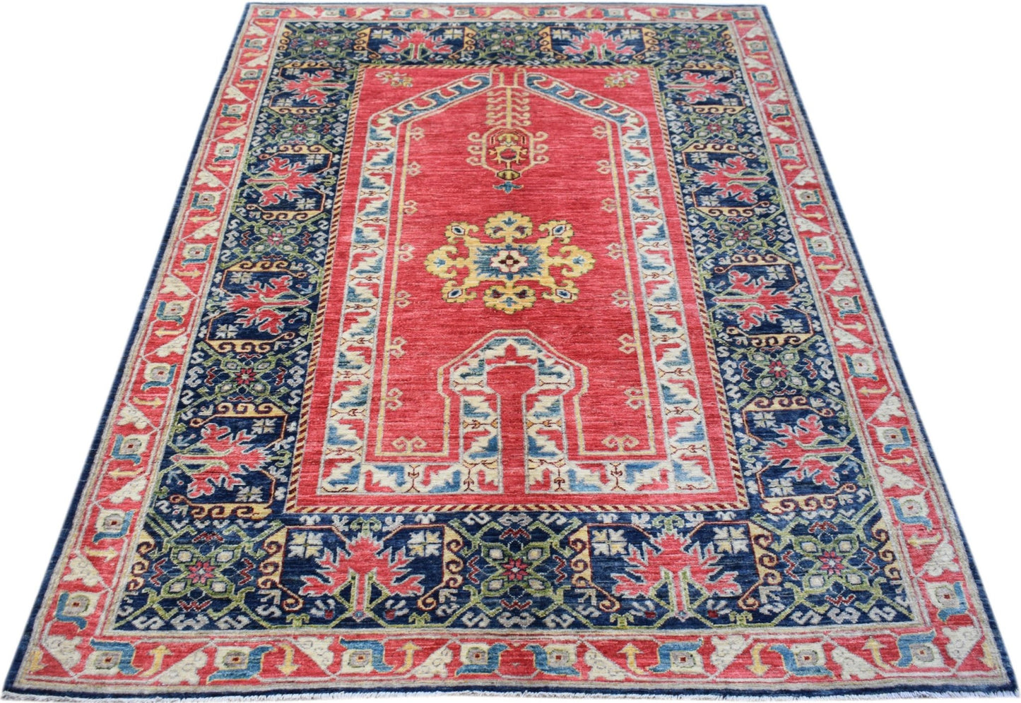 A rectangular Afghan Chobi rug featuring a red field with a central medallion and blue borders.
