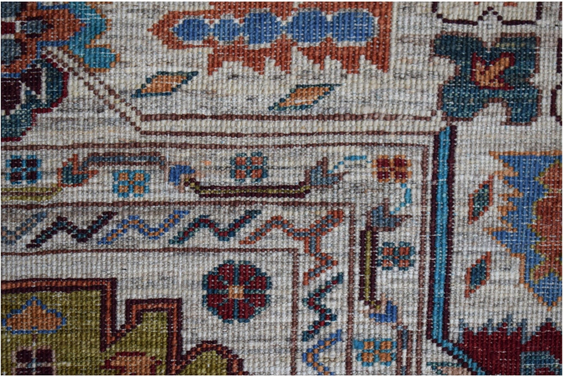 A close-up of an Afghan Chobi rug featuring intricate geometric patterns in earthy tones.