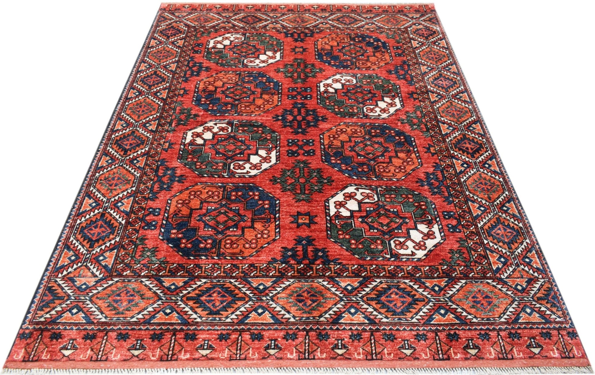 Handwoven Afghan Chobi rug featuring a red field with repeating geometric octagonal medallions.