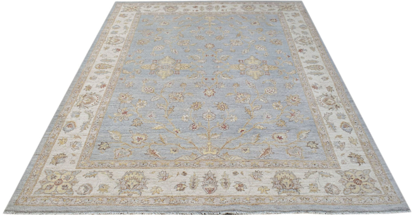 A handmade Afghan Chobi rug featuring a traditional floral pattern in soft blue and beige tones.