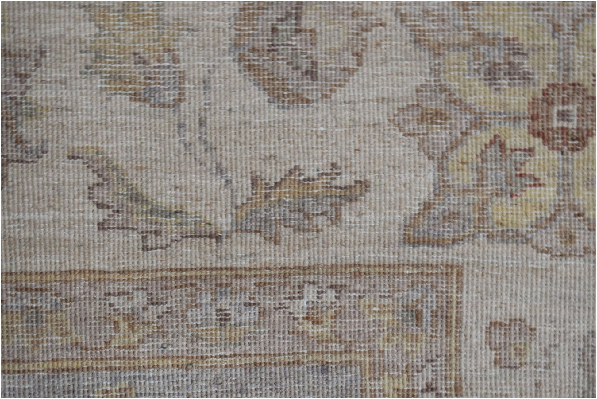 A close-up of a handwoven Afghan Chobi rug featuring traditional floral patterns in earthy tones.